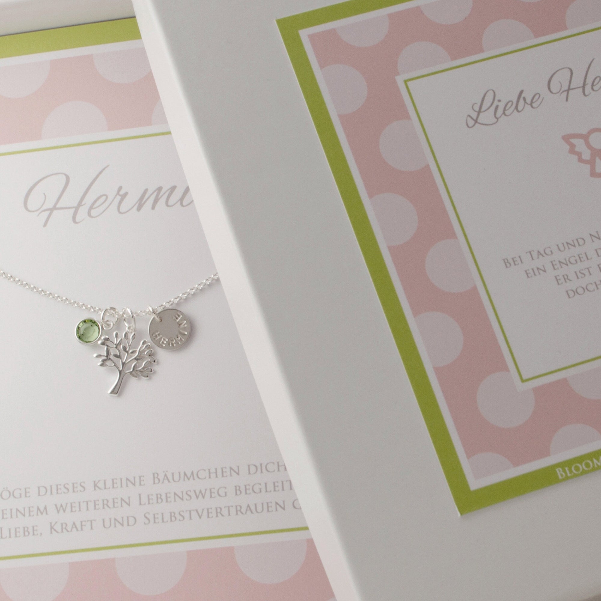 Personalisierte Lebensbaum-Kette aus 925 Silber mit Namensgravur und peridot grünem Geburtsstein, präsentiert in einer Geschenkbox mit Spruch: "Möge dieses kleine Bäumchen dich auf deinem weiteren Lebensweg begleiten und beschützen..."