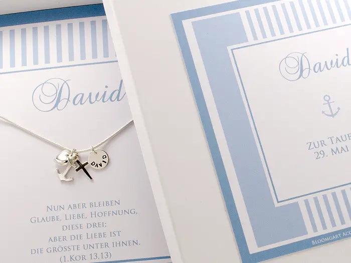 Personalisierte hellblaue Geschenkbox zur Taufe mit einer 925 Sterling Silber Taufkette für Jungen mit Namengravur, Herz, Kreuz und Anker als Zeichen für Glaube, Liebe und Hoffnung.