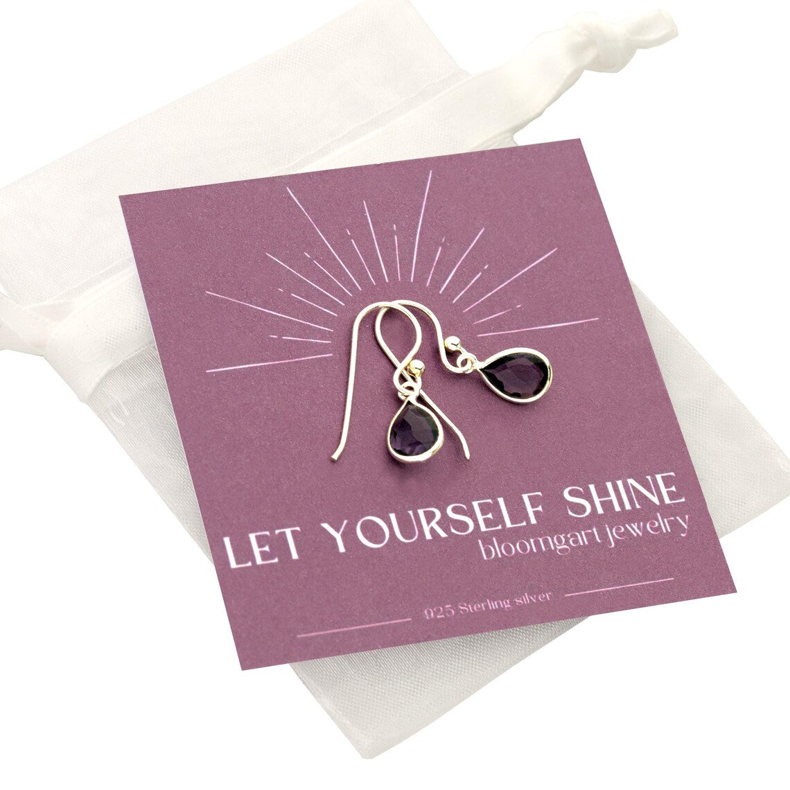 Zierliche Tropfen-Ohrringe mit lila Amethyst und 925 Sterling Silber Fassung auf einer Geschenkkarte 'Let yourself shine' befestigt und in einem weißen Organzasäckchen verpackt.
