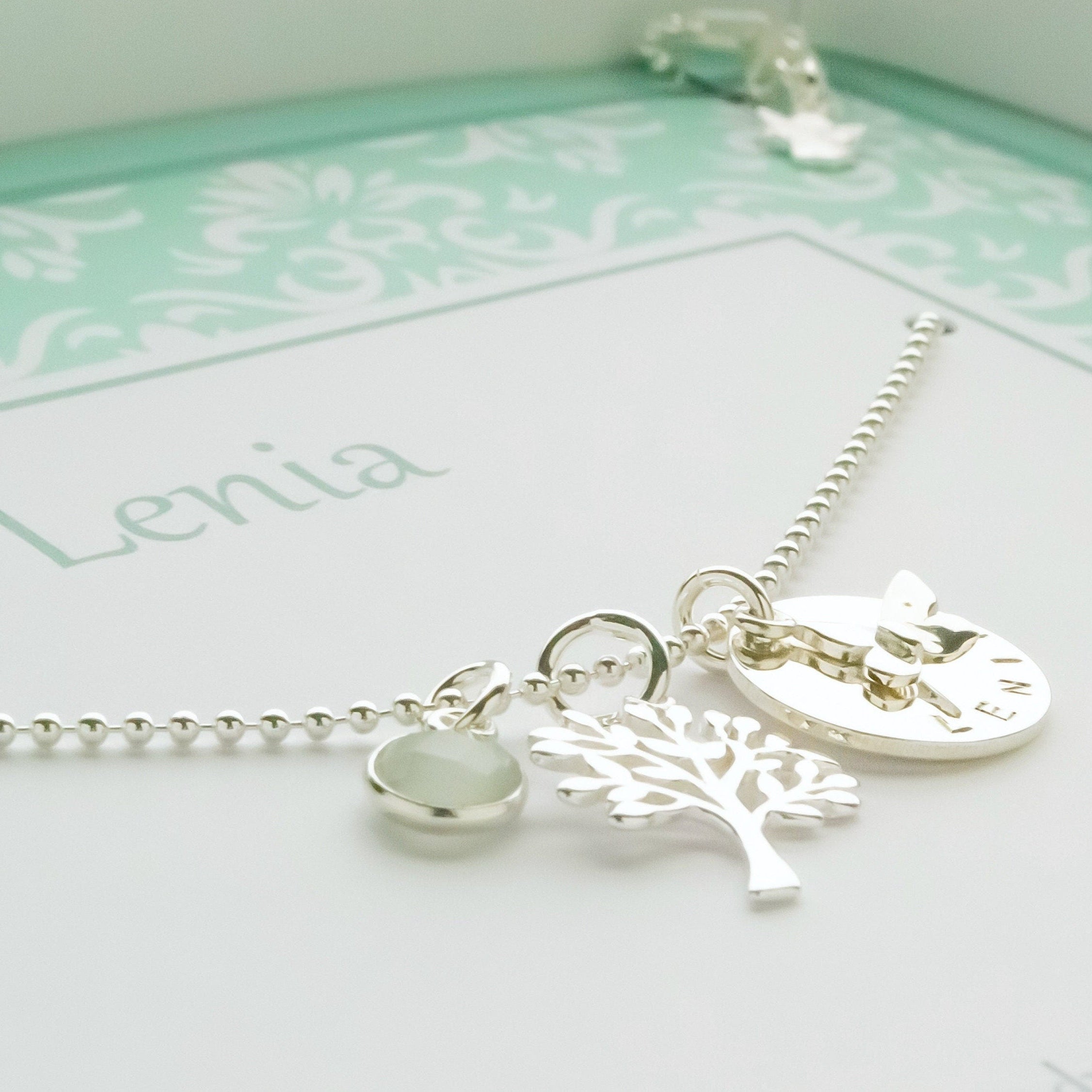 Detailansicht der einzelnen Anhänger an der Namenskette für 'LENIA'.