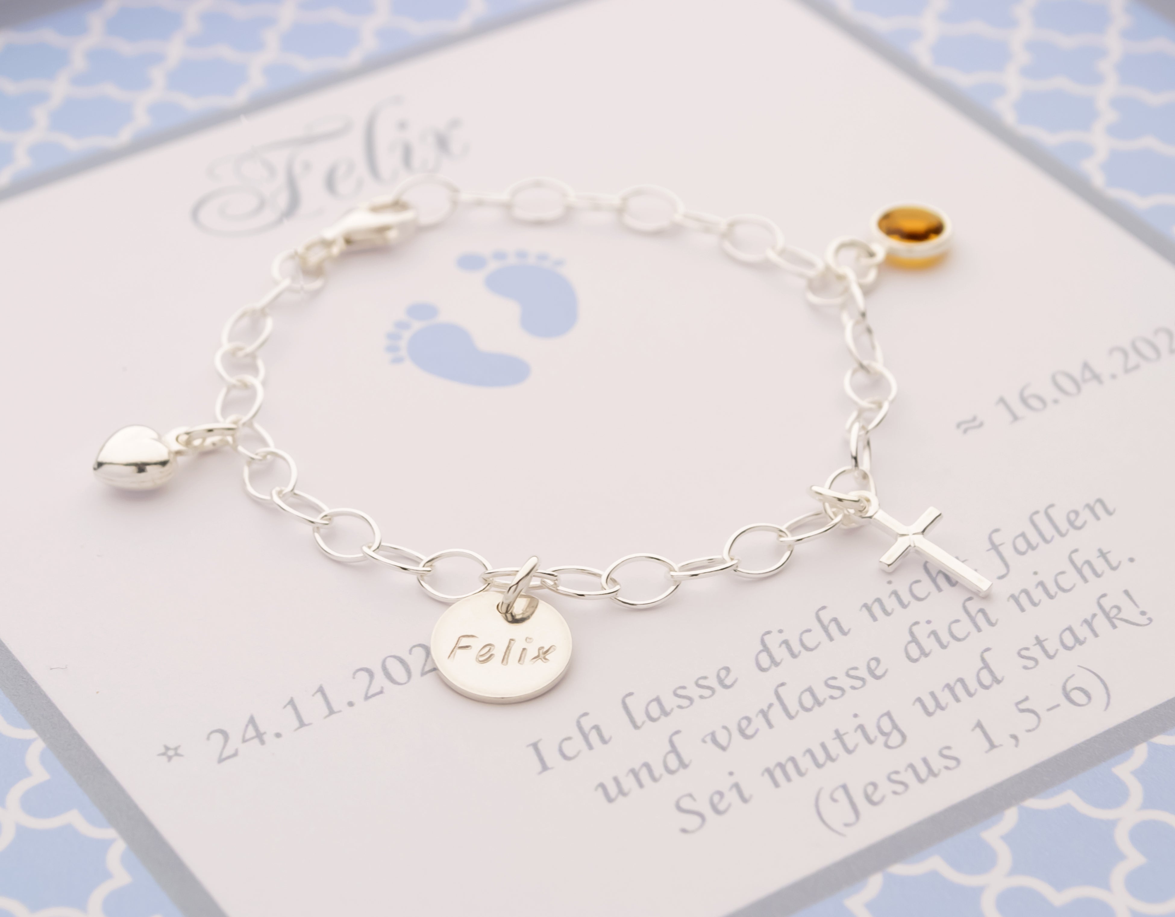Nahaufnahme der feinen Namensgravur auf dem Silberplättchen des Taufarmbands 'Felix'.