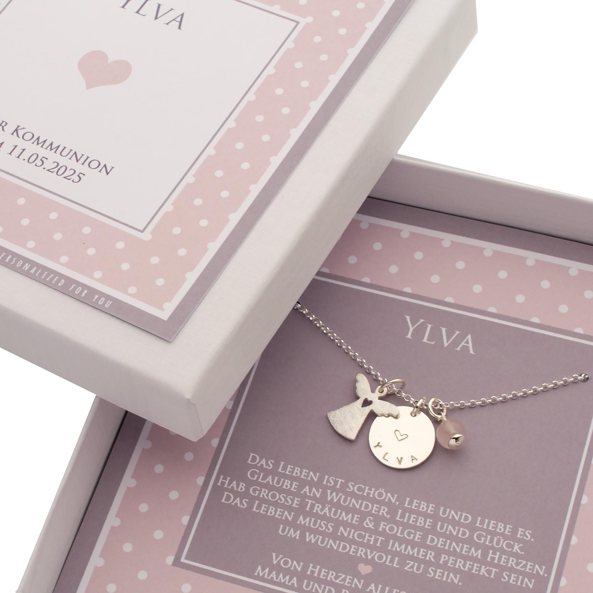 Detailansicht einer engelsrufer-Kette aus Sterlingsilber mit Namensplättchen, Engel und Heilsteinkugel nach Wunsch. Die Kette wird präsentiert in einer rosa-weiß gepunkteten Geschenkbox, personalisiert mit Namen, Anlass und Glückwünschen.
