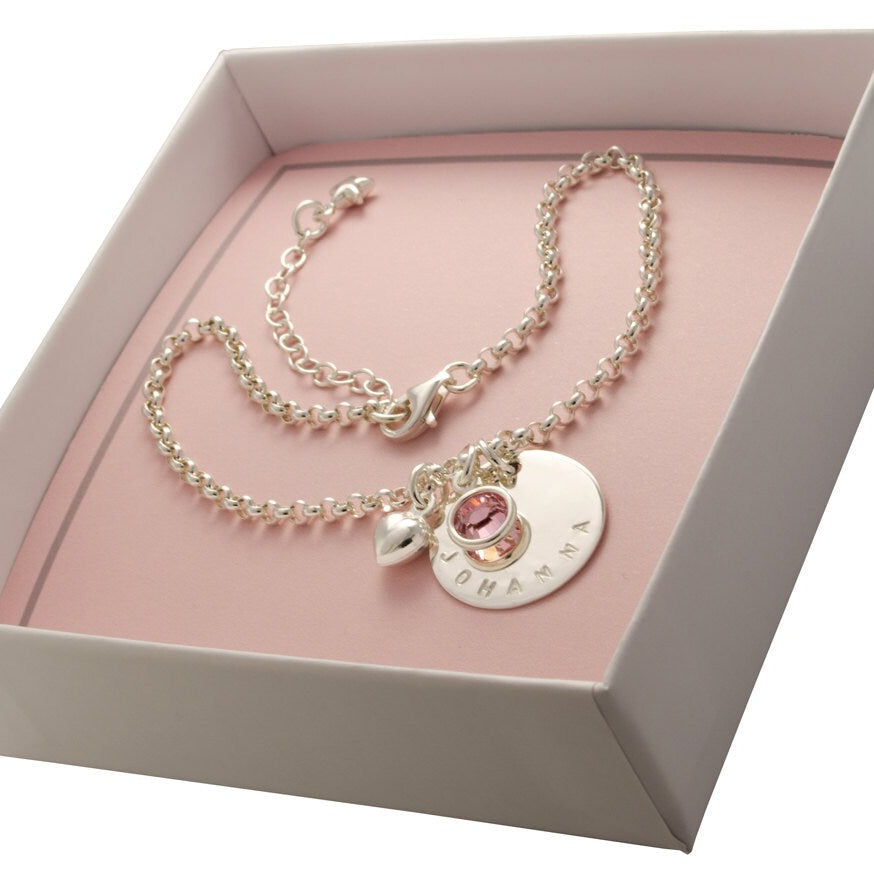 Namensarmband aus 925 Sterling Silber, hier mit dem Namen 'JOHANNA' von Hand gestempelt und rosa Geburtsstein in einer rosa-weißen BLOOMGART Geschenkbox.
