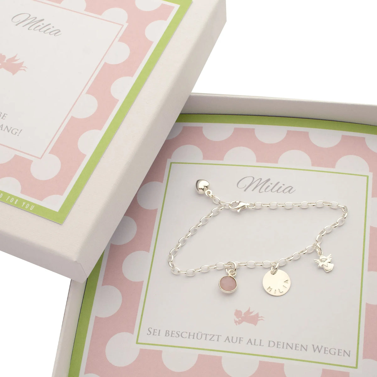 Ein personalisiertes Geschenk zum Schulanfang von Eltern, Großeltern oder Paten: Silberarmband mit Namensgravur, Engel und Geburtsstein in rosa-weißer Geschenkbox.