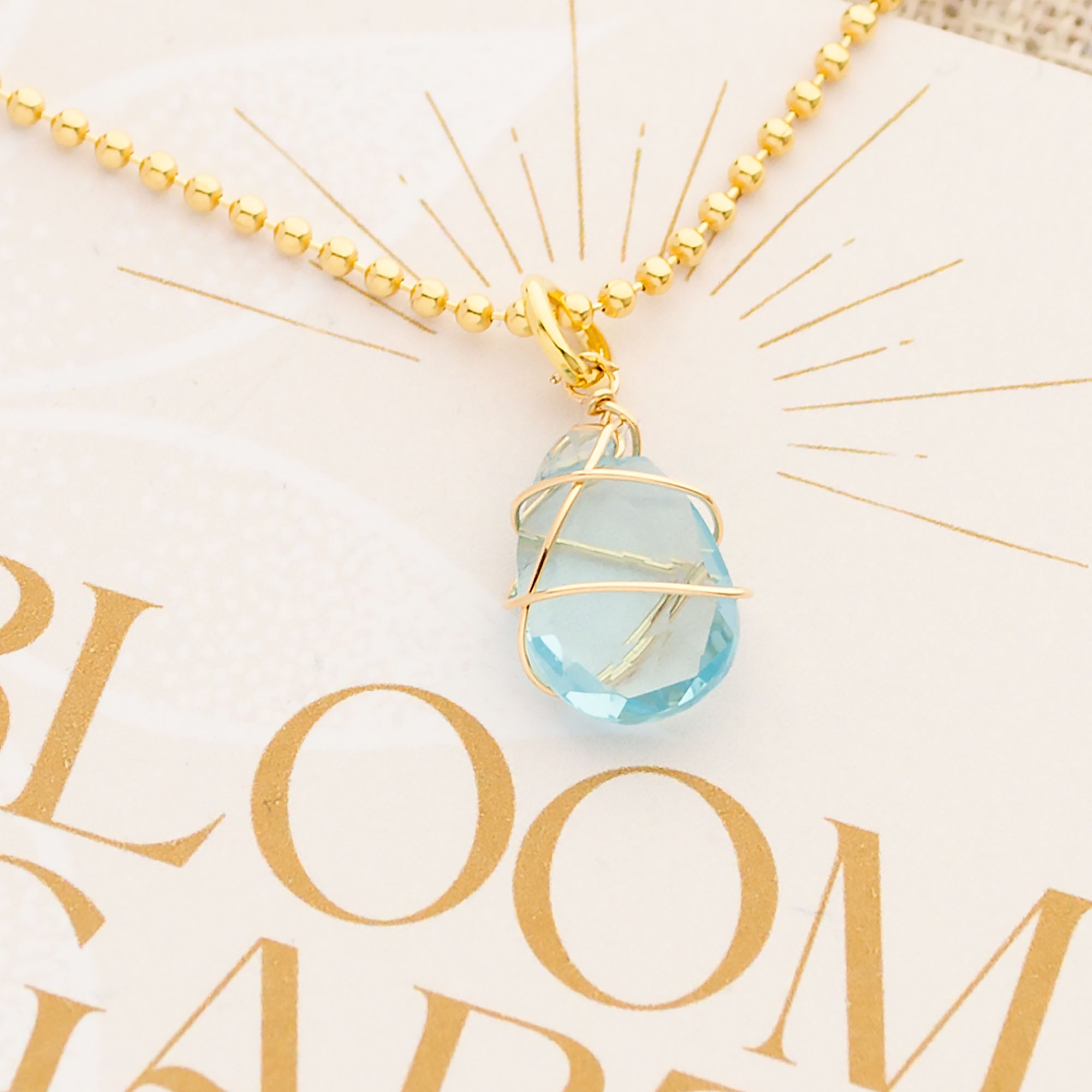 Detailansicht einer Sterlingsilber vergoldeten Kugelkette mit hellblauem Aqua Chalcedon und Gold-Umwickelung von Hand gefertigt.