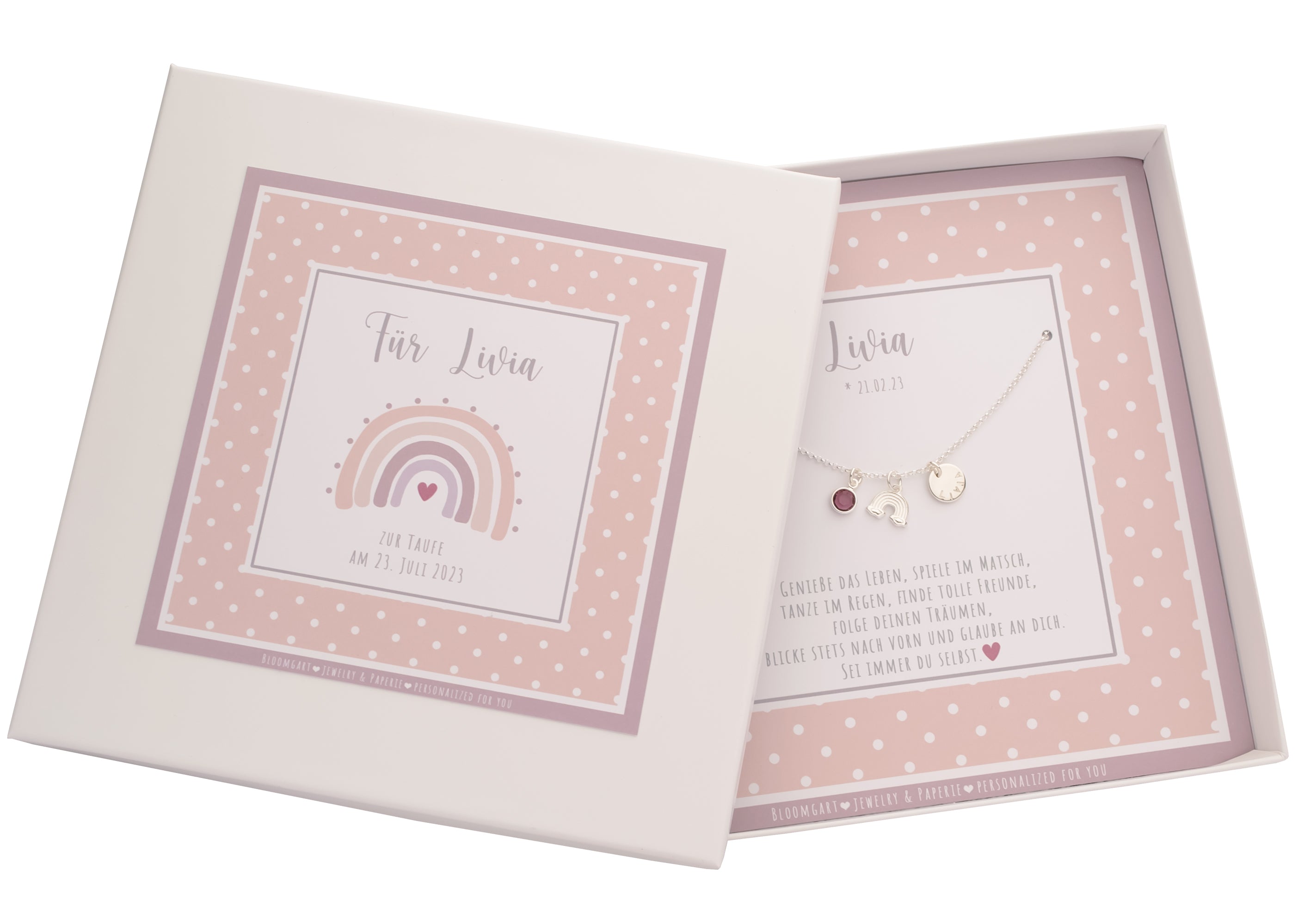 Komplettansicht einer rosa Geschenkbox, personalisiert zur Taufe von 'Livia'. Innen ist der Spruch 'Genieße das Leben, spiele im Matsch, tanze im Regen, finde tolle Freunde... gedruckt.