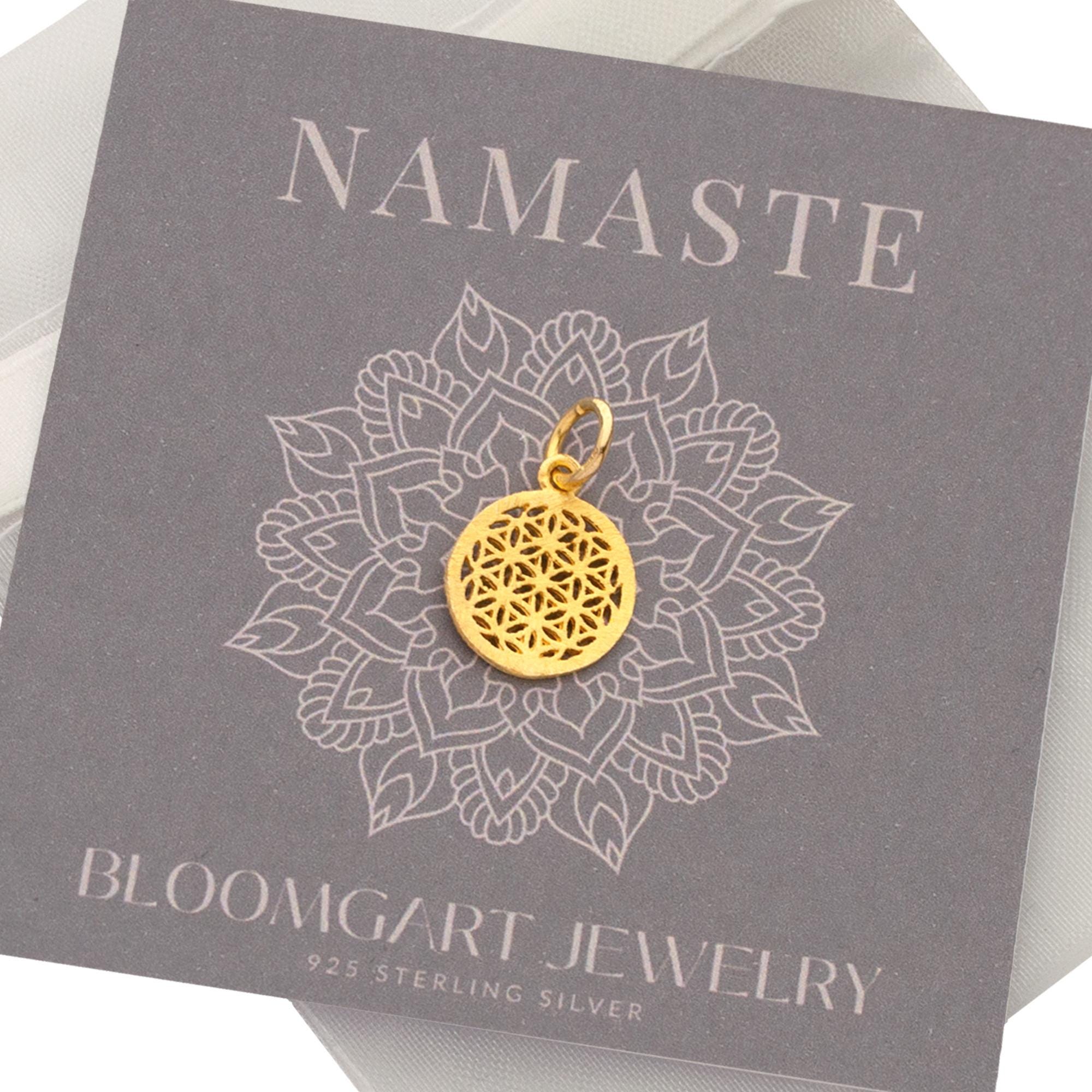 Filigraner Glücksbringer in Form einer Lebensblume aus vergoldetem 925 Sterling Silber als Einzelanhänger auf einer mit Namaste Blume verzierten Karte.