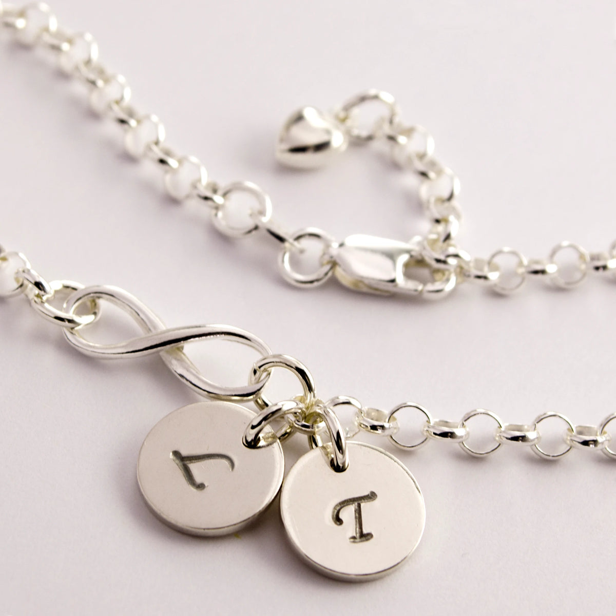 Infinity-Armband aus 925 Silber mit Herz und zwei Plättchen für Initialen.