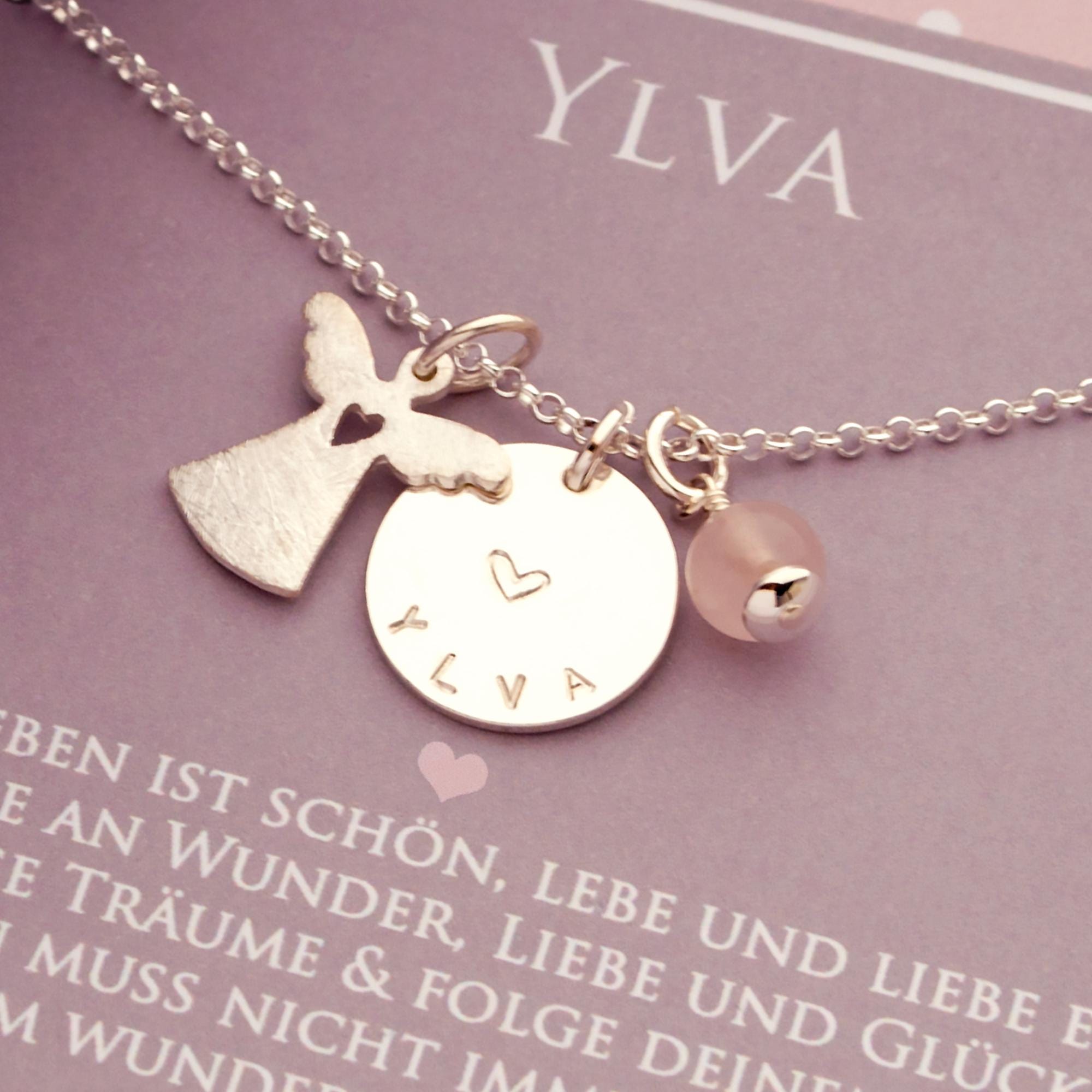 Detailansicht einer filigranen Erbskette aus Sterlingsilber mit Engel, Gravurtaler und Edelstein-Kugel auf einer personalisierten Geschenkbox.