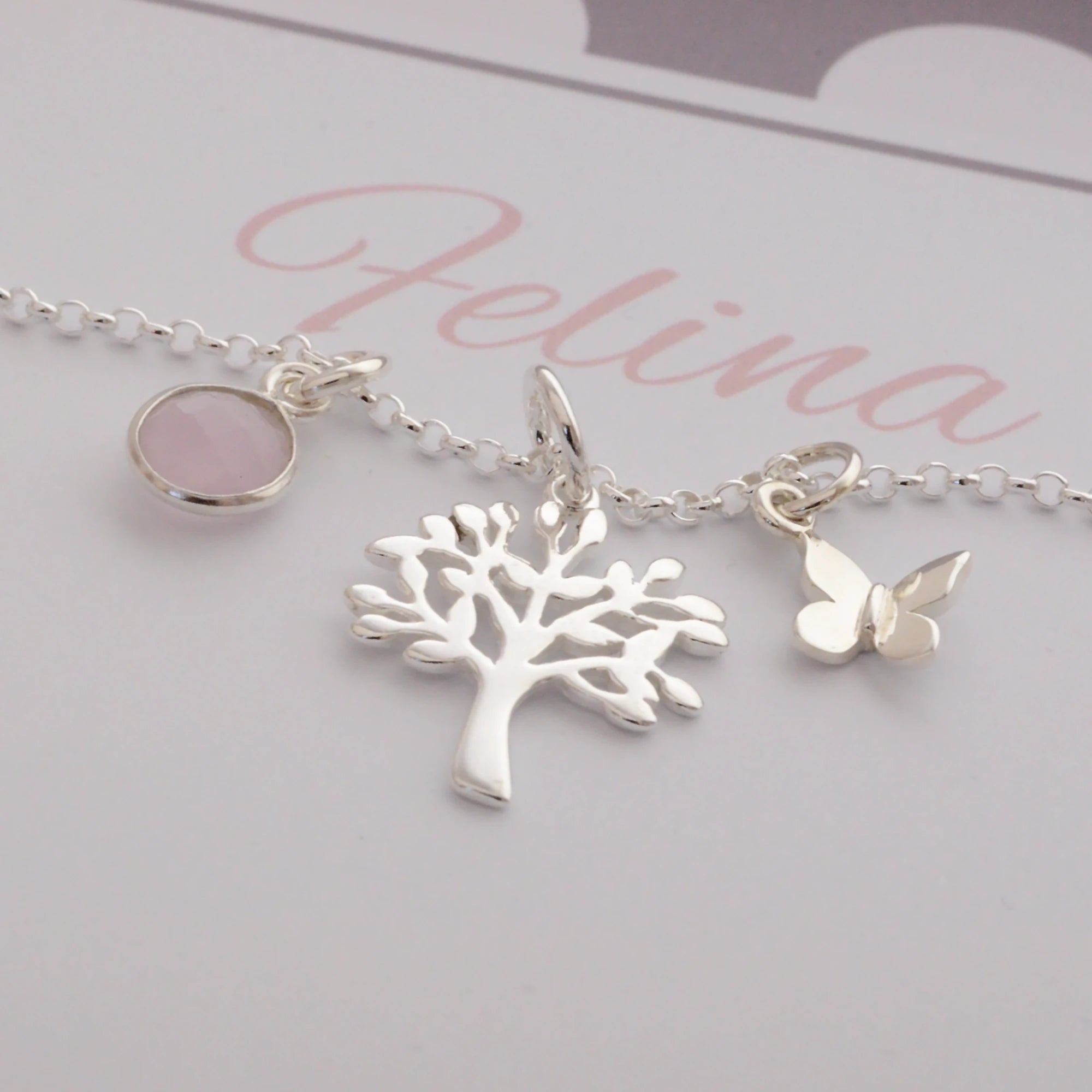 Detailansicht einer zarten Halskette mit Lebensbaum, rundem Edelstein und Schmetterling aus Sterling Silber.