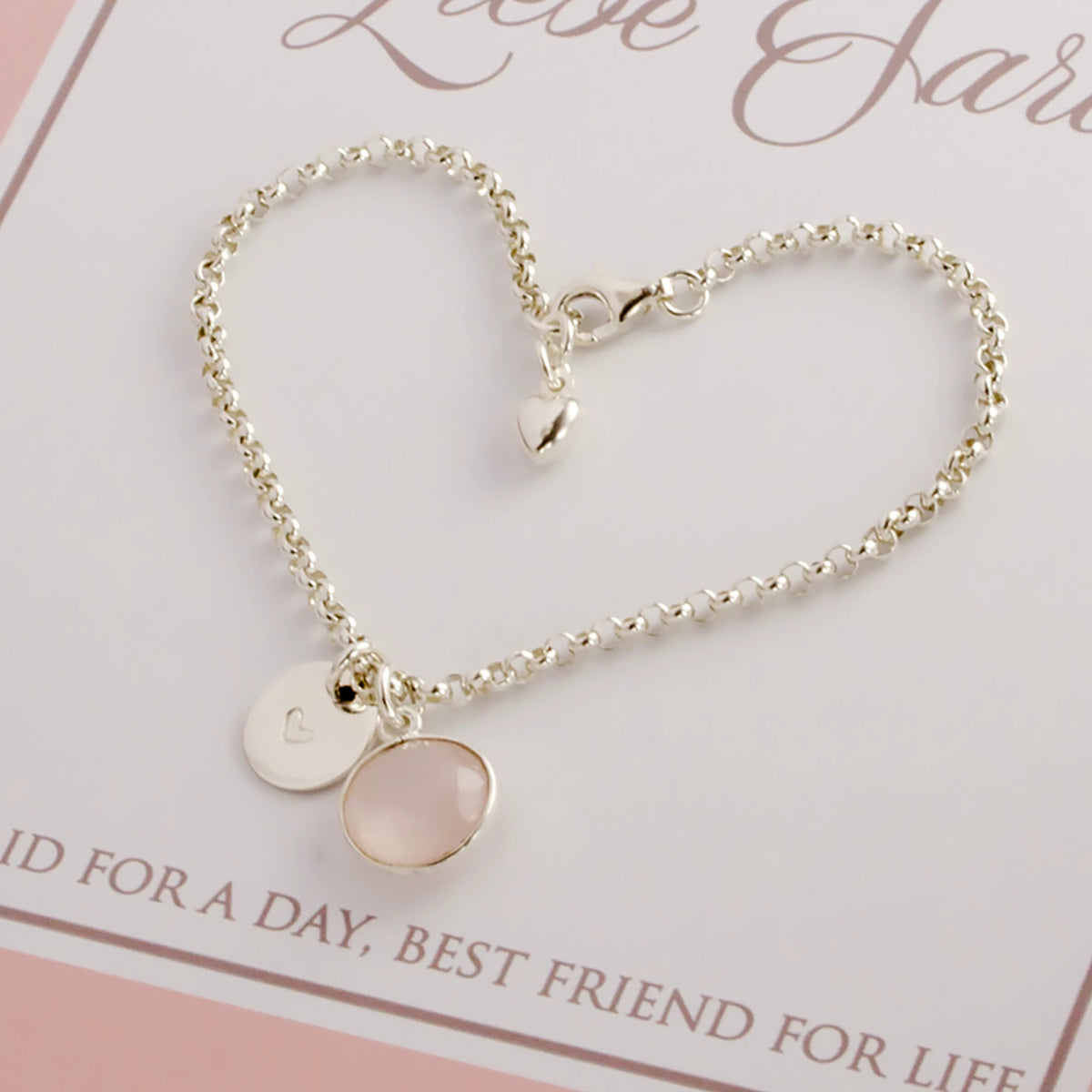 Ein Hochzeitsgeschenk für die Trauzeugin. Detailansicht einer 925 Silberarmbandes mit Herz-Gravur und Edelstein-Anhänger.