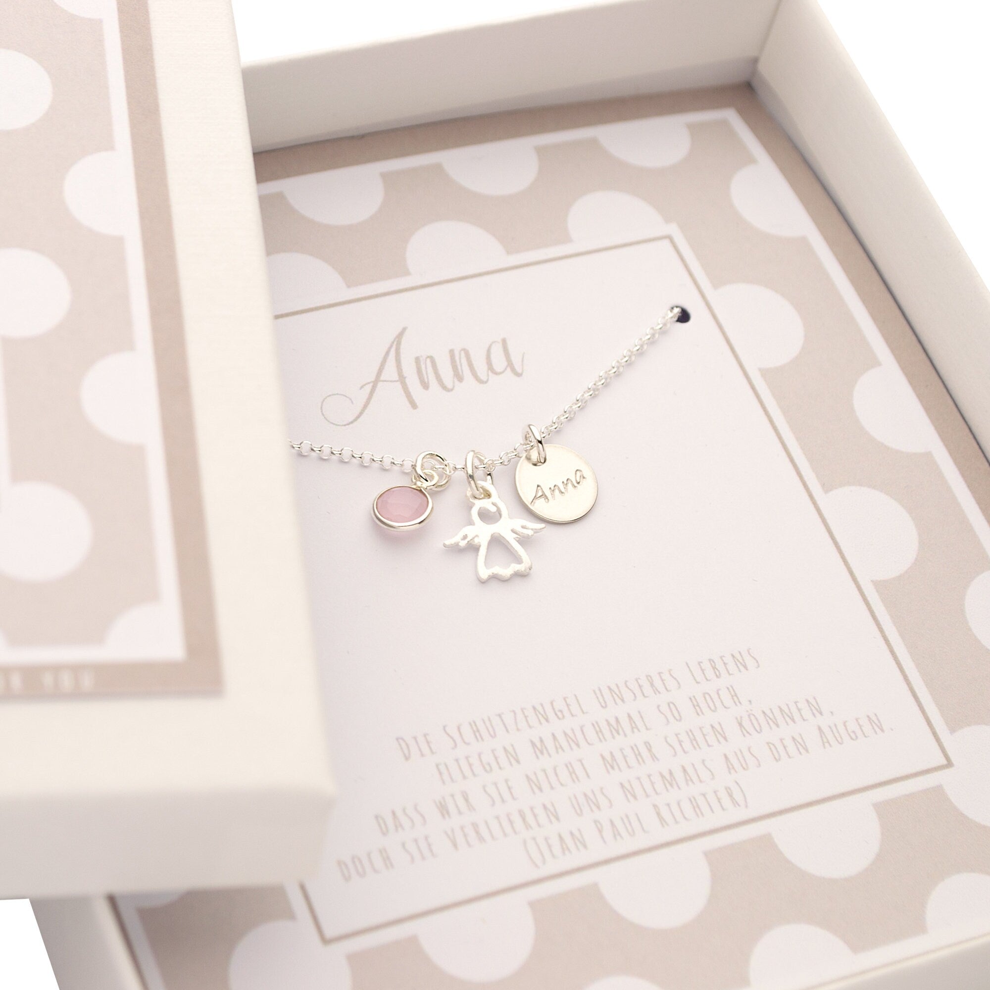 Innenansicht einer beige-weiß gepunkteten Geschenkbox mit filigraner Silberkette, personalisiert für 'Anna' mit Schutzengel Spruch.