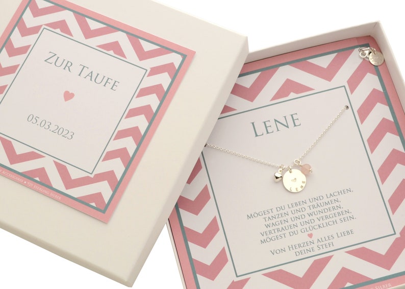 Komplettansicht einer personalisierten Geschenkbox mit filigrane Erbskette mit den Anhängern: bauchiges Herz, großer Namenstaler, hier mit dem Namen 'Lene' und einem Herz mittig gestempelt sowie einer Rosenquarz-Kugel. Am Verschluss ist ein Datum-Plättchen befestigt. Die Kette ist in der Box montiert.