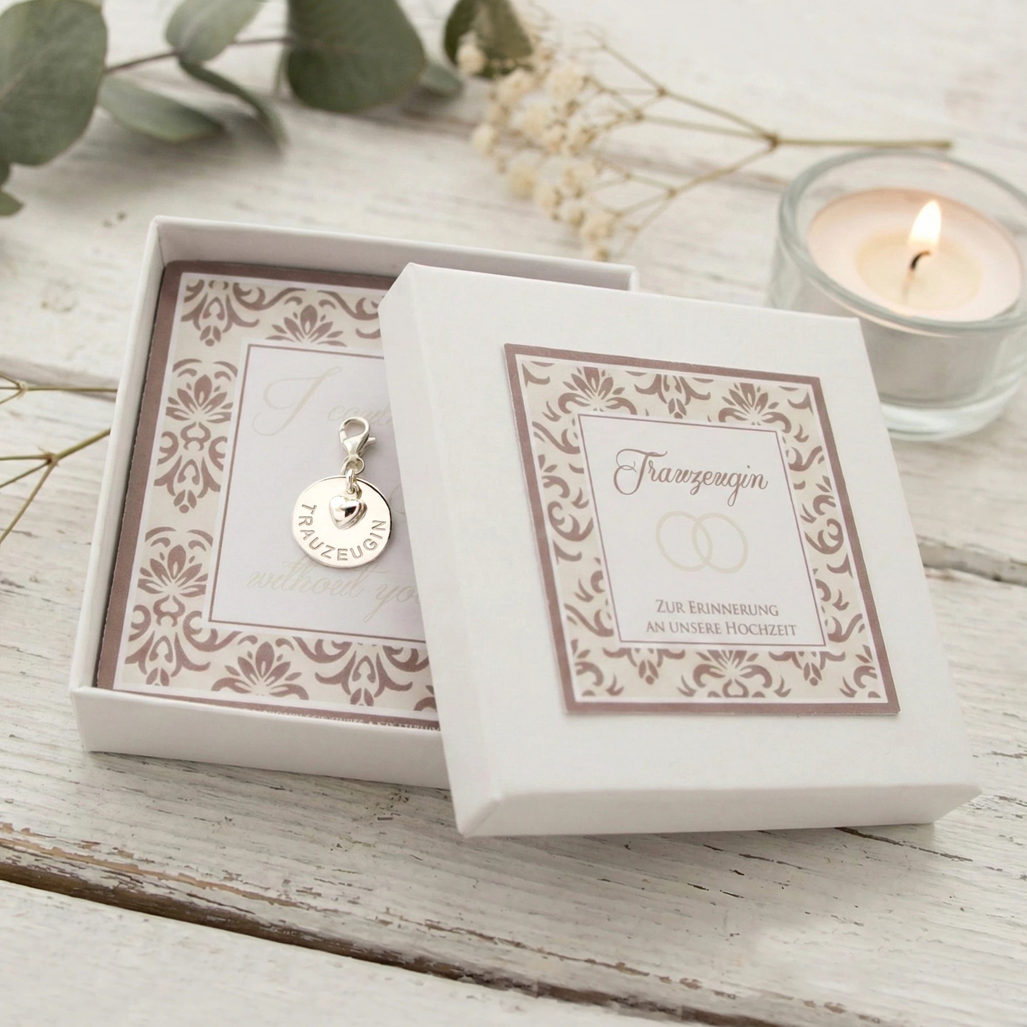 Geschenk für Trauzeugin: ein Silberanhänger mit der Gravur TRAUZEUGIN und Herz an einem Karabiner in weißer elegant bedruckter Hochzeitsschachtel.