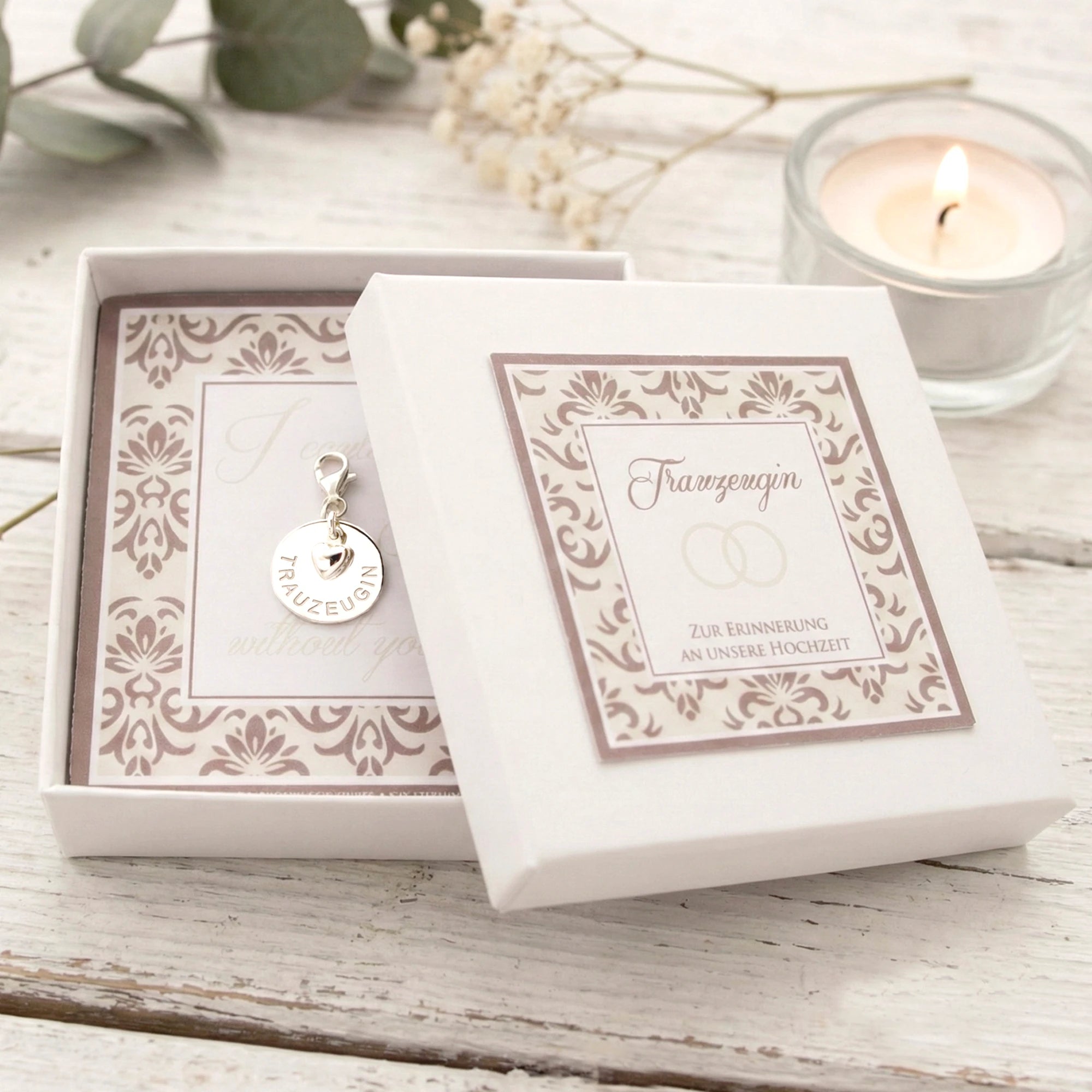 Geschenkidee für Trauzeugin mit Silberanhänger Gravur und Herz in einer weißer Schachtel auf einem festlich geschmückten weißen Tisch präsentiert.