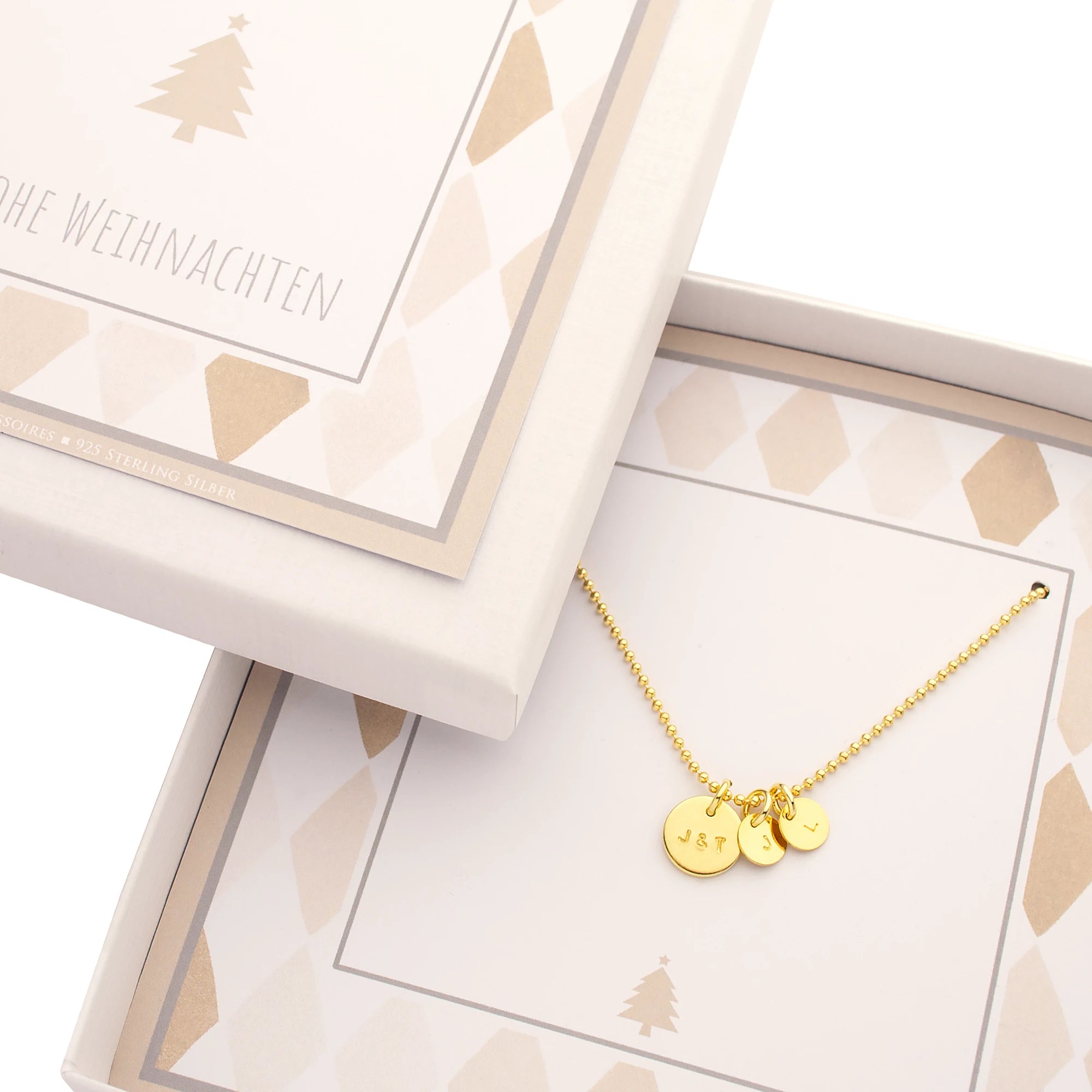 Vergoldete Kette aus 925 Sterling Silber mit drei gravierten Initial-Plättchen (J&T, J, L) in einer beige-weißen "FROHE WEIHNACHTEN" Geschenkbox.