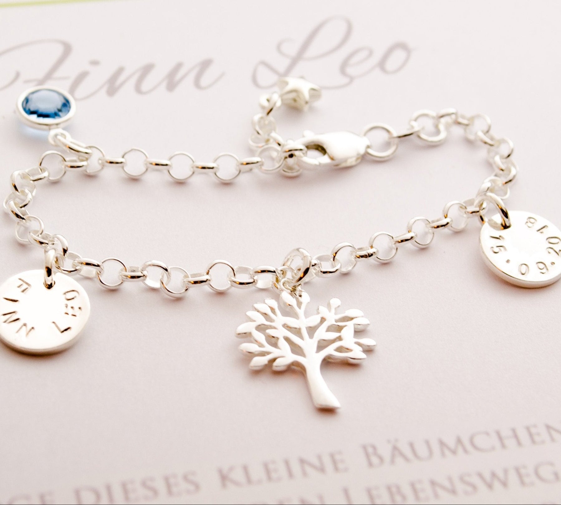 Detailansicht eines Namensarmbandes mit zwei Gravurplättchen für Name und Datum, Lebensbaum und Geburtsstein. 925 Silber Armband in Bloomgart Geschenkbox Geschenk zur Geburt, Taufe, Einschulung oder Namenstag.