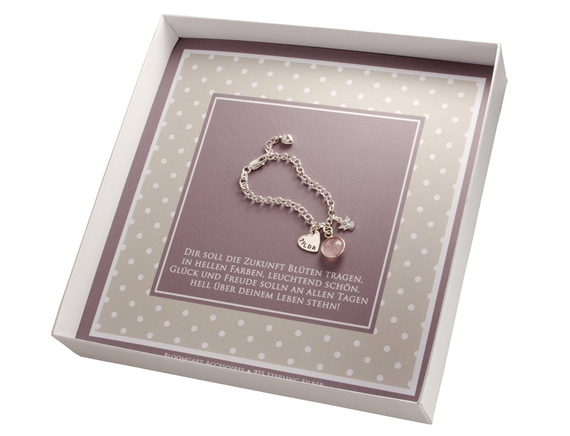 Innenansicht der Geschenkbox mit Taufarmband mit Herz-Anhänger, Schutzengel und Rosenquarz. Das Armband ist in der Länge verstellbar und liegt in einer personalisierten Geschenkbox in weiß-beige-braun Tönen im Pünktchen Design.