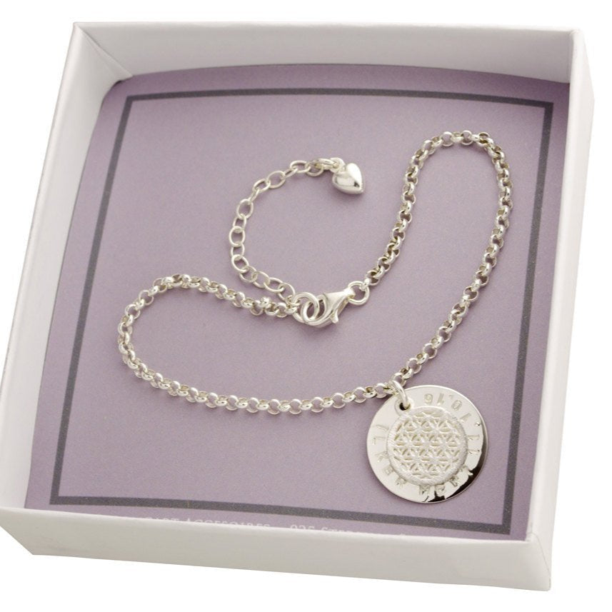 Innenansicht einer kleinen weiß-grauen Geschekschachtel mit Namensarmband aus 925 Silber mit Lebensblume und großem Gravurtaler mit Wunschgravur, handgemacht von Bloomgart.