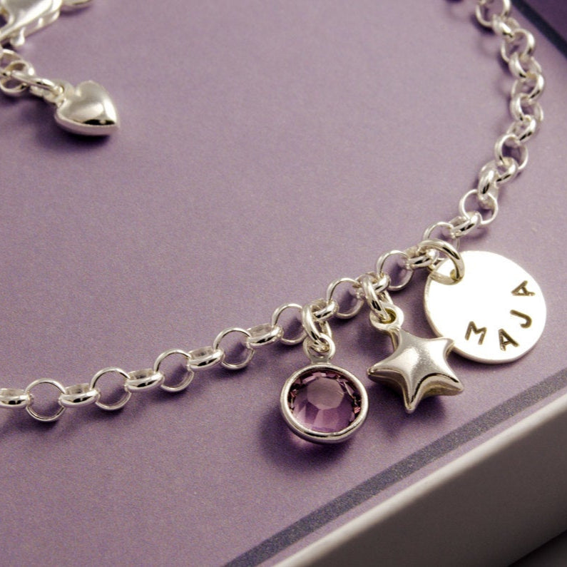 Gliederarmband mit Namenstaler, Glücksstern und Geburtsstein als glückbringendes Namensarmband in einer kleinen Geschenkbox präsentiert.