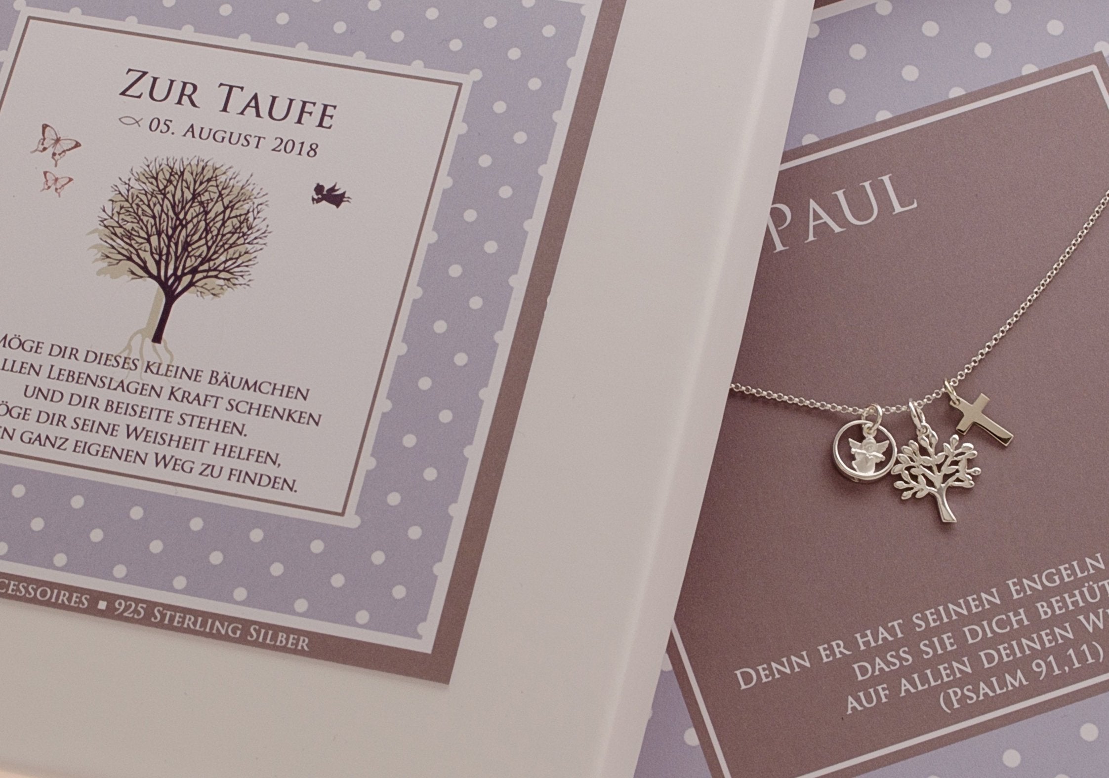 Ein wunderbares Geschenk zur Taufe ist dieser Taufschmuck für Jungen. Eine zarte Silberkette mit Engel, Kreuz und Lebensbaum in einer personalisierten Geschenkbox mit Pünktchen-Design in hellblau-grau-weiß.