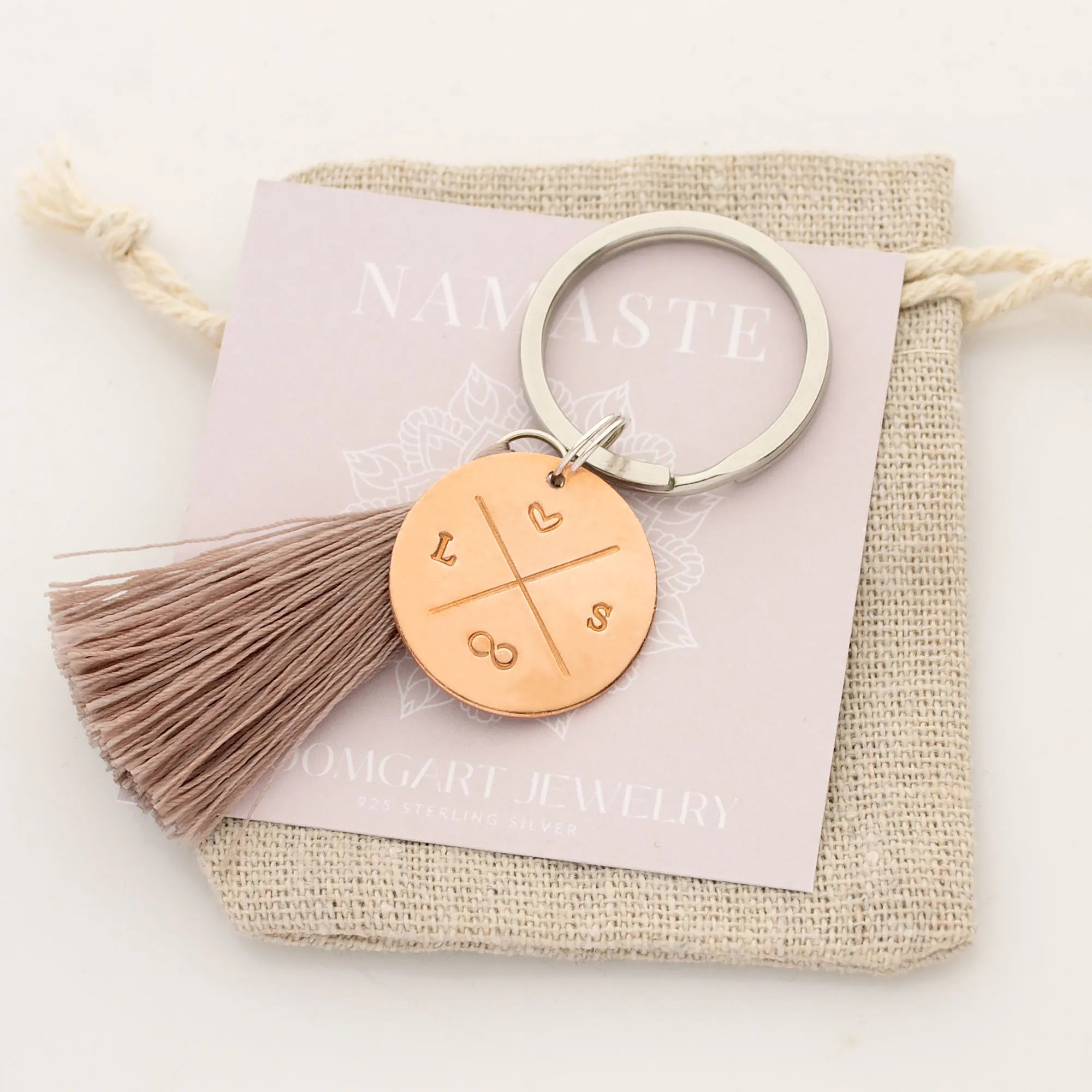 Personalisierter Schlüsselanhänger aus Kupfer mit Initialen, Herz und Unendlichkeitszeichen, handgestempelt, verpackt im Leinen-Säckchen von Bloomgart.
