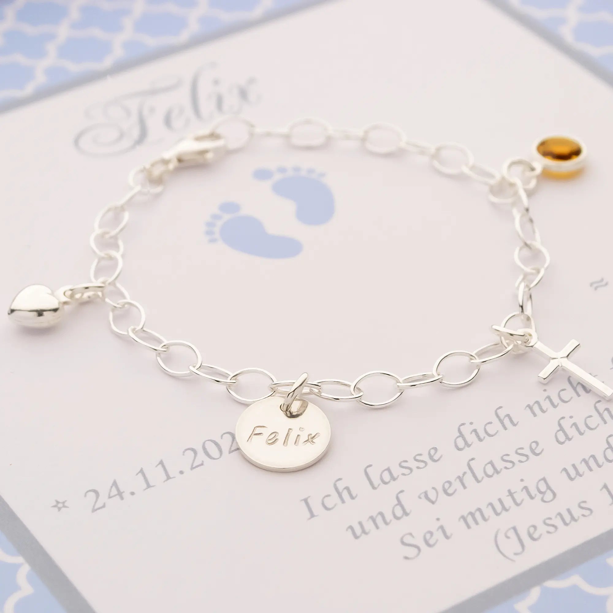 Nahaufnahme der feinen Namensgravur auf dem Silberplättchen des Taufarmbands 'Felix'.
