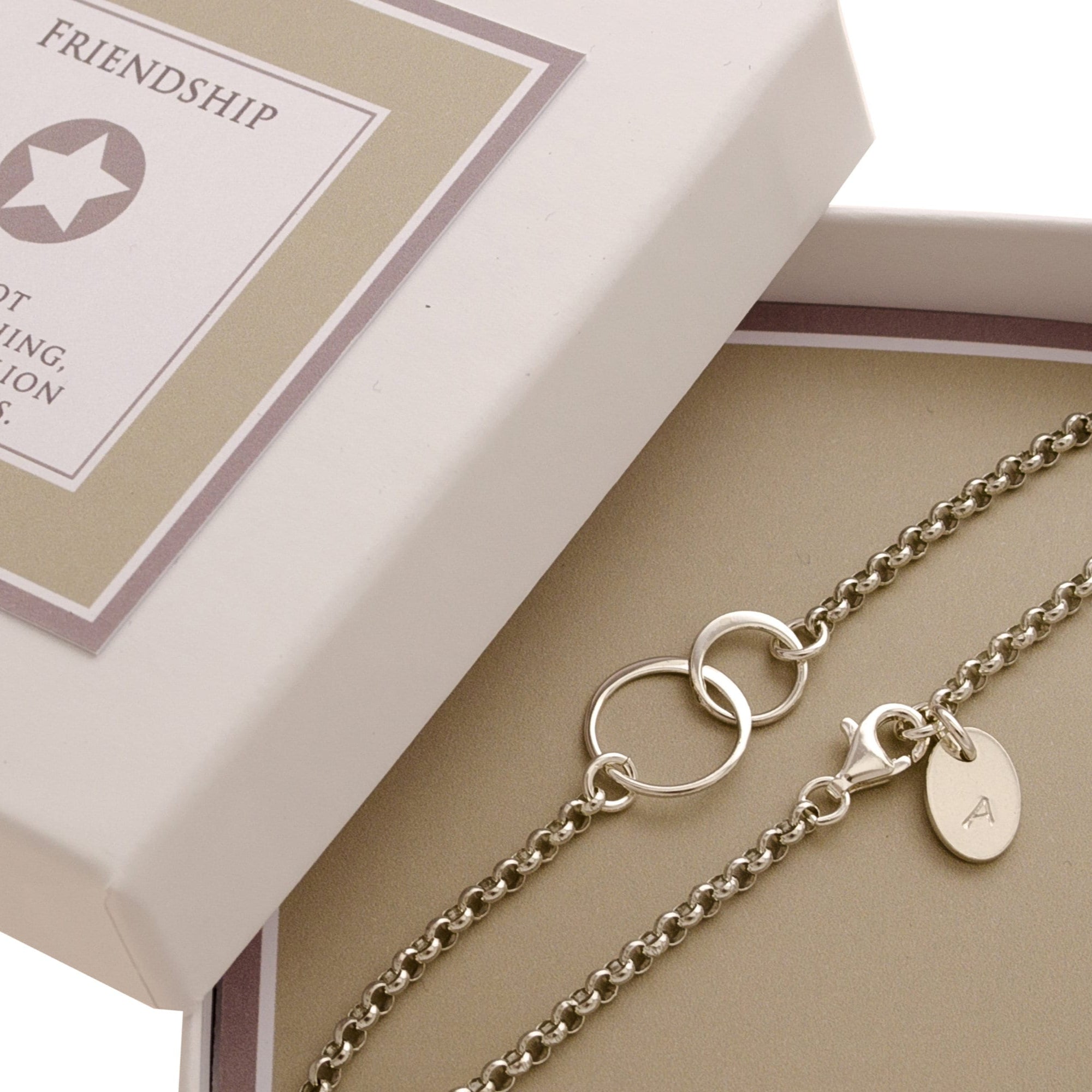 Freundschaftsarmband "Verschlungen" aus 925 Silber mit Initialen, präsentiert in einer beigen Geschenkbox mit dem englischen Freundschafts-Spruch: "Friendship is not one big thing, but one million little things."