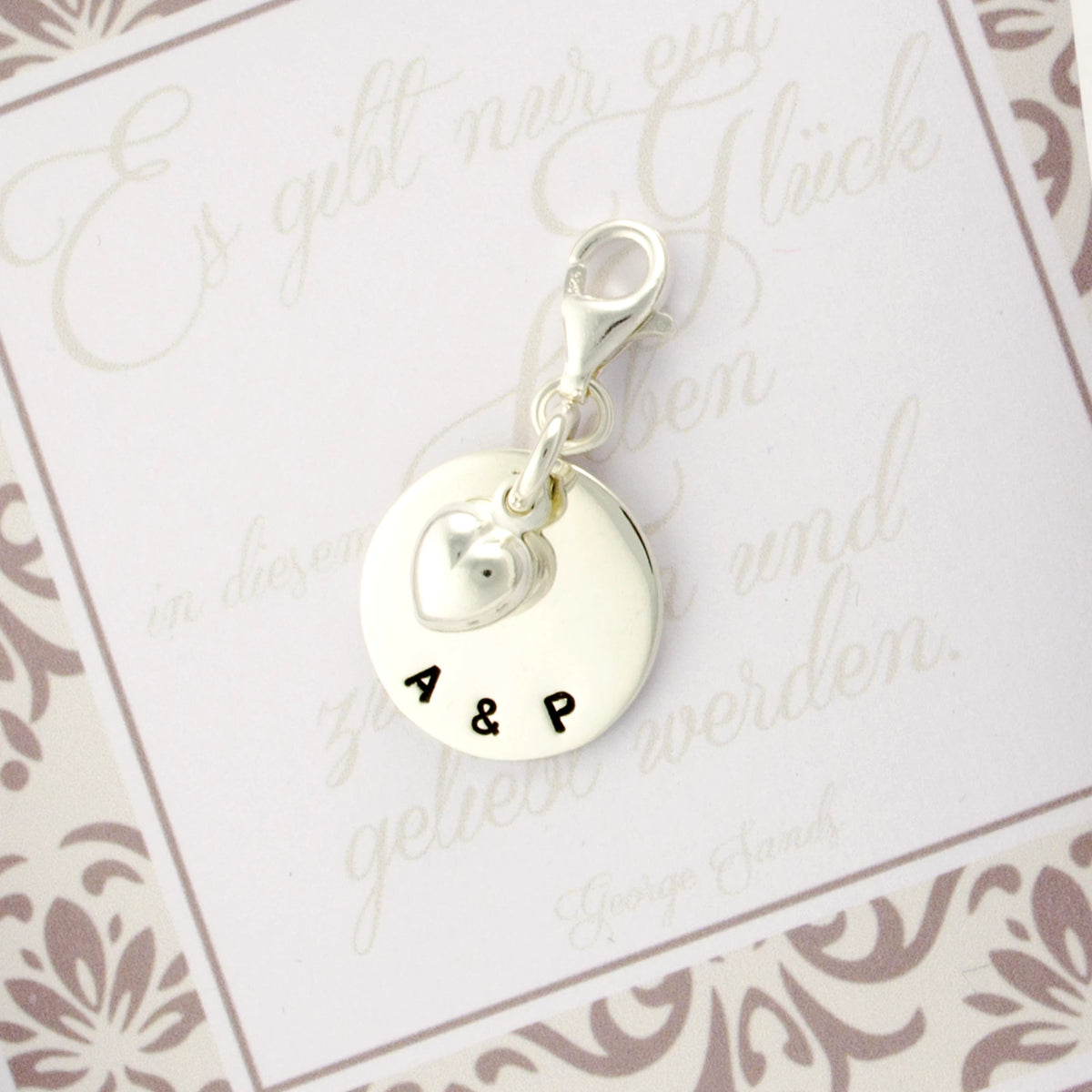 Silberanhänger mit gravierten Initialen als persönliches Hochzeitsgeschenk.