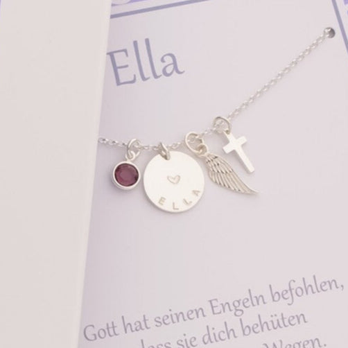 Personalisierte Kette zur Kommunion für "Ella" aus 925 Silber mit Kreuz, Engelsflügel und Amethyst, präsentiert in einer lila Geschenkbox von Opa und Oma.