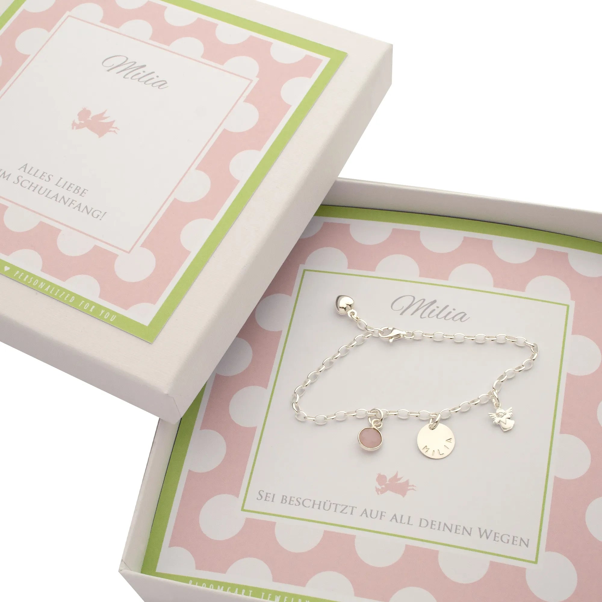 Ein Geschenk zur Einschulung mit personalisierter Geschenkbox für das Schulkind. Innen liegt ein Silberarmband mit den Anhängern: Rosenquarz, Namenstaler und Engel.
