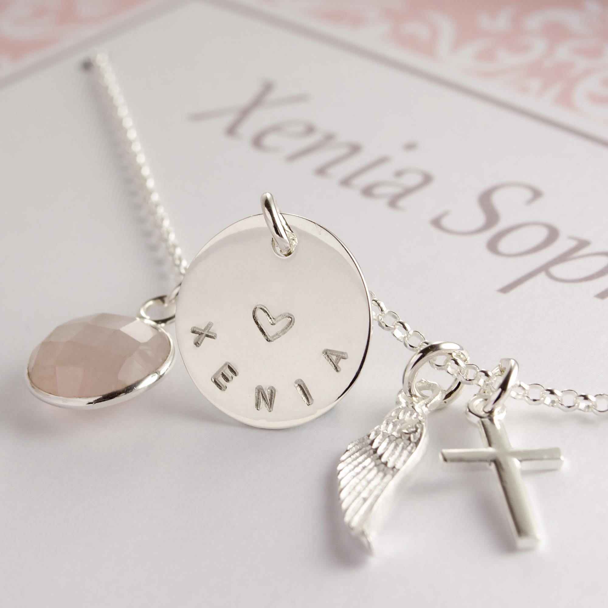 Detailansicht der Anhänger Rosenquarz, Namenstaler, Flügel und Kreuz aus 925 Sterling Silber an einer filigranen Silberkette.