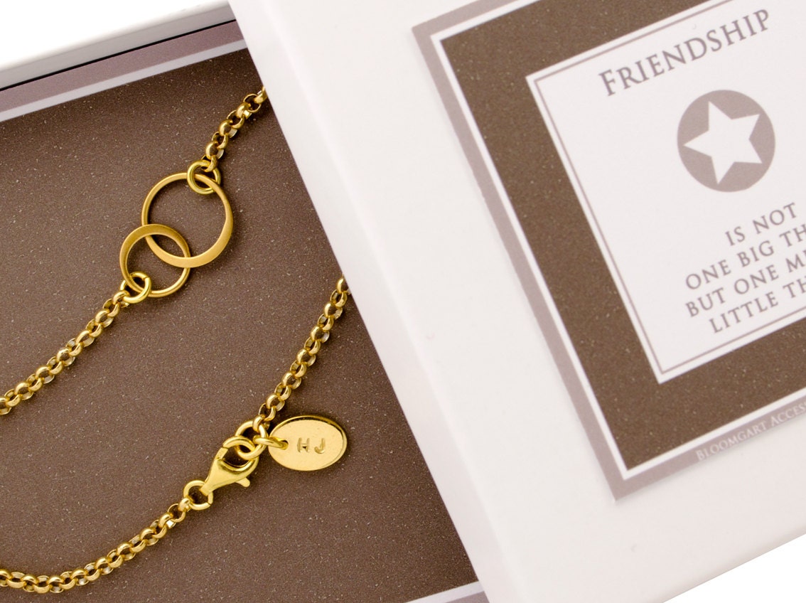 Gold-Variante des Freundschaftsarmbandes 'Verschlungen' mit Initial am Verschluss in einer weiß-braunen Geschenkbox.