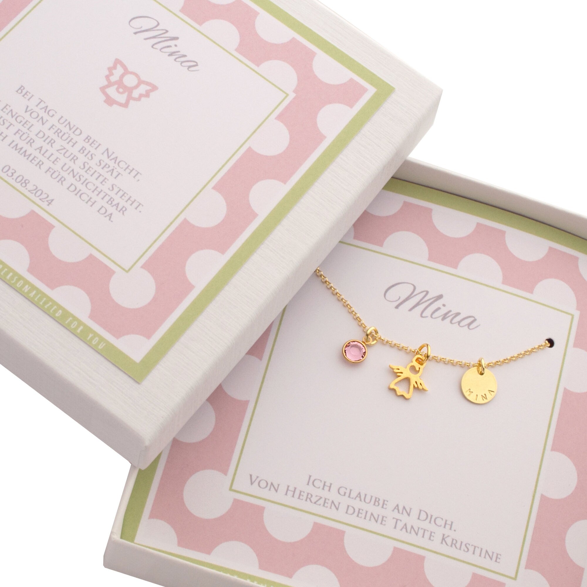 Personalisierte Geschenkbox mit rosa-weißem Punktemuster mit lindgrünem Rand präsentiert eine goldene Schutzengelkette mit Geburtsstein und Name.