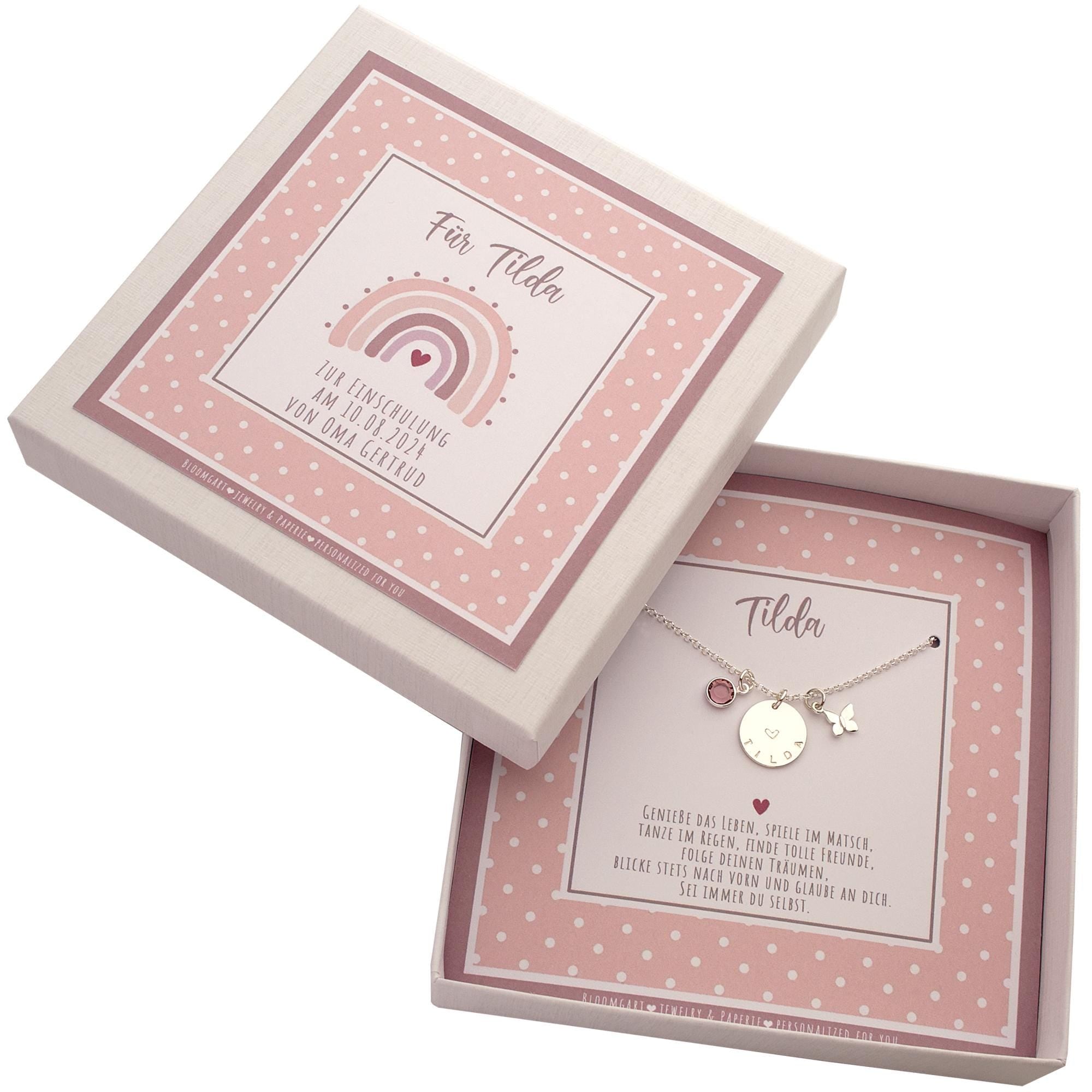 Personalisierte Halskette zur Einschulung für 'Tilda' mit Namensgravur und Schmetterling in einer rosa Geschenkbox mit Regenbogen-Motiv und persönlichem Spruch von Oma Gertrud. Ein Geschenk zum Schulanfang von Bloomgart.