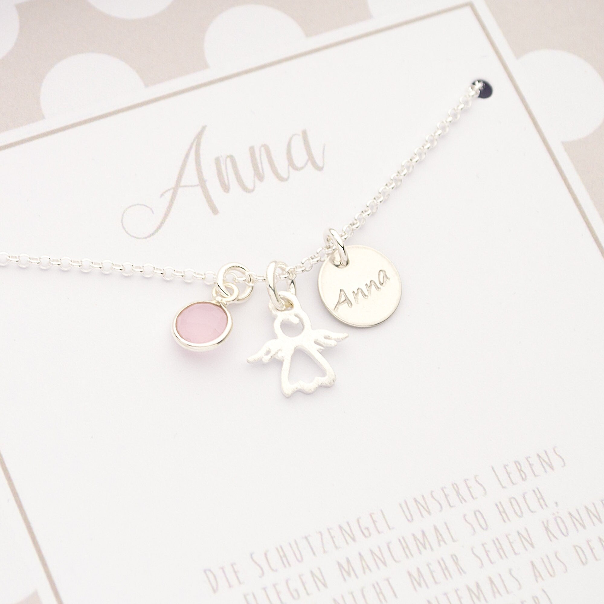 Detailansicht einer filigranen Erbskette aus 925 Silber, personalisiert für 'Anna' mit Namenstaler, Engel und Rosenquarz.