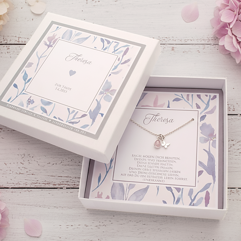 Personalisierte Silberkette "Theresa" aus Sterlingsilber mit Schmetterling-Anhänger und Edelstein-Tropfen (hier ein Rosenquarz) in einer floralen, personalisierten Geschenkbox. Arrangiert auf einem alten weißen Holztisch mit Blumendeko.