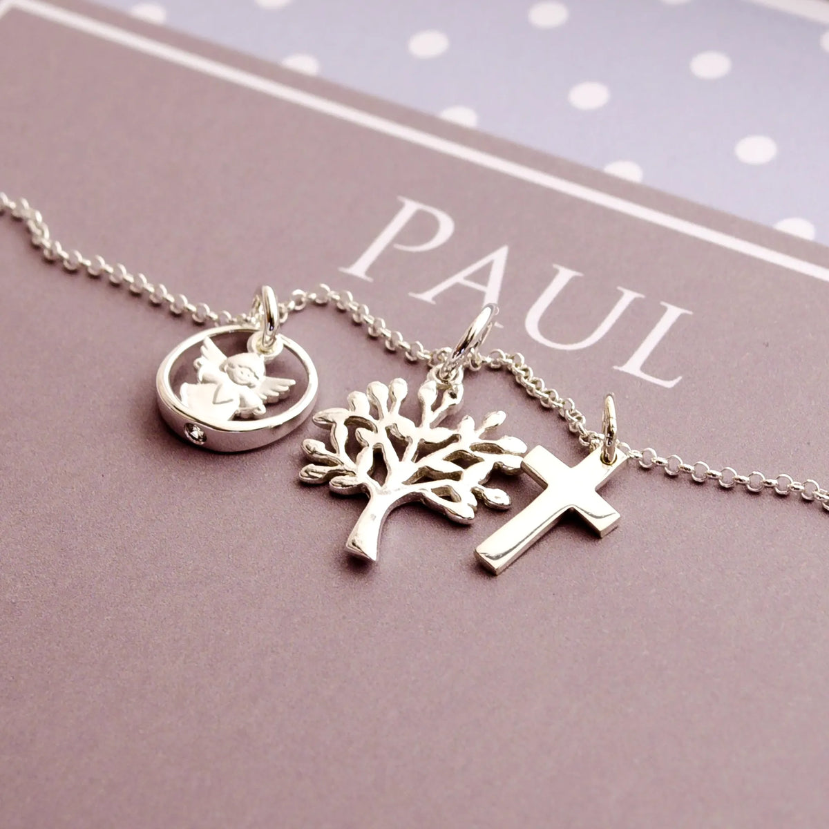 Detailansicht einer Taufkette für Jungen mit Kreuz, Lebensbaum und Schutzengel im Taufring an einer filigranen Erbskette aus 925 Sterling Silber. 