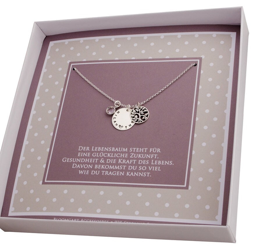 Innenansicht einer Geschenkschachtel in beige-braun-Tönen mit innenliegender, personalisierter Lebensbaum Kette aus 925 Sterling Silber mit 18 mm Gravurtaler, Geburtsstein April und rundem Lebensbaum-Anhänger. Unter der Kette steht der Spruch 'Der Lebensbaum steht für eine glückliche Zukunft, Gesundheit und die Kraft des Lebens...'