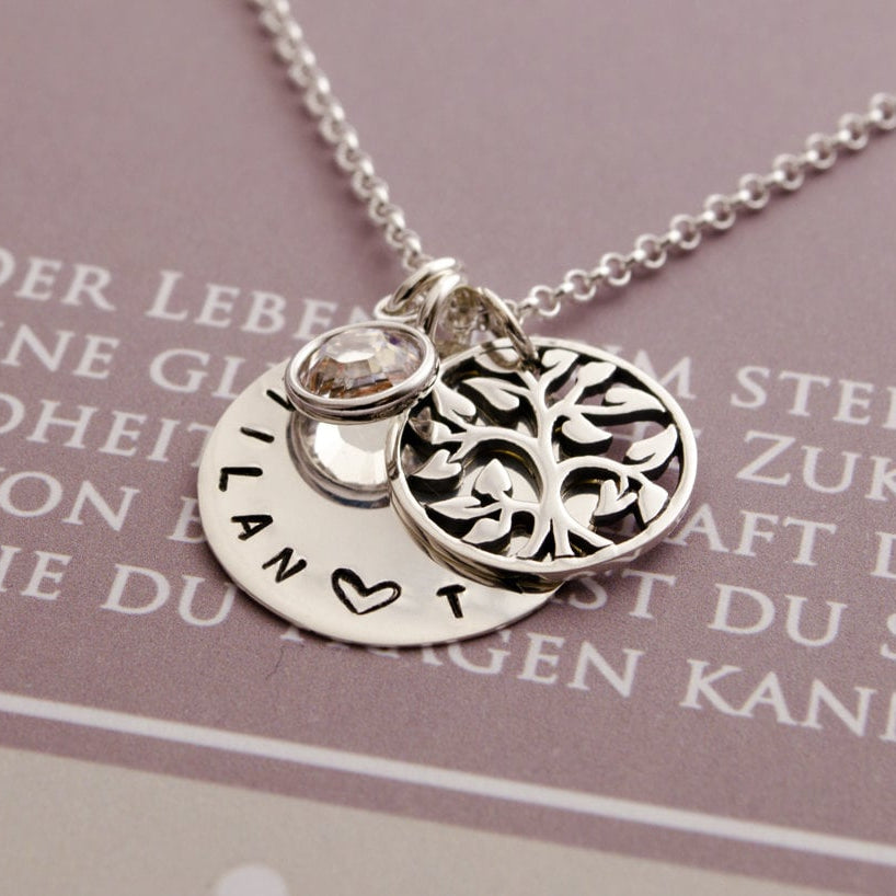 Nahansicht einer personalisierten Namenskette aus 925 Sterling Silber mit Lebensbaum und Monatsstein in einer Geschenkbox präsentiert.