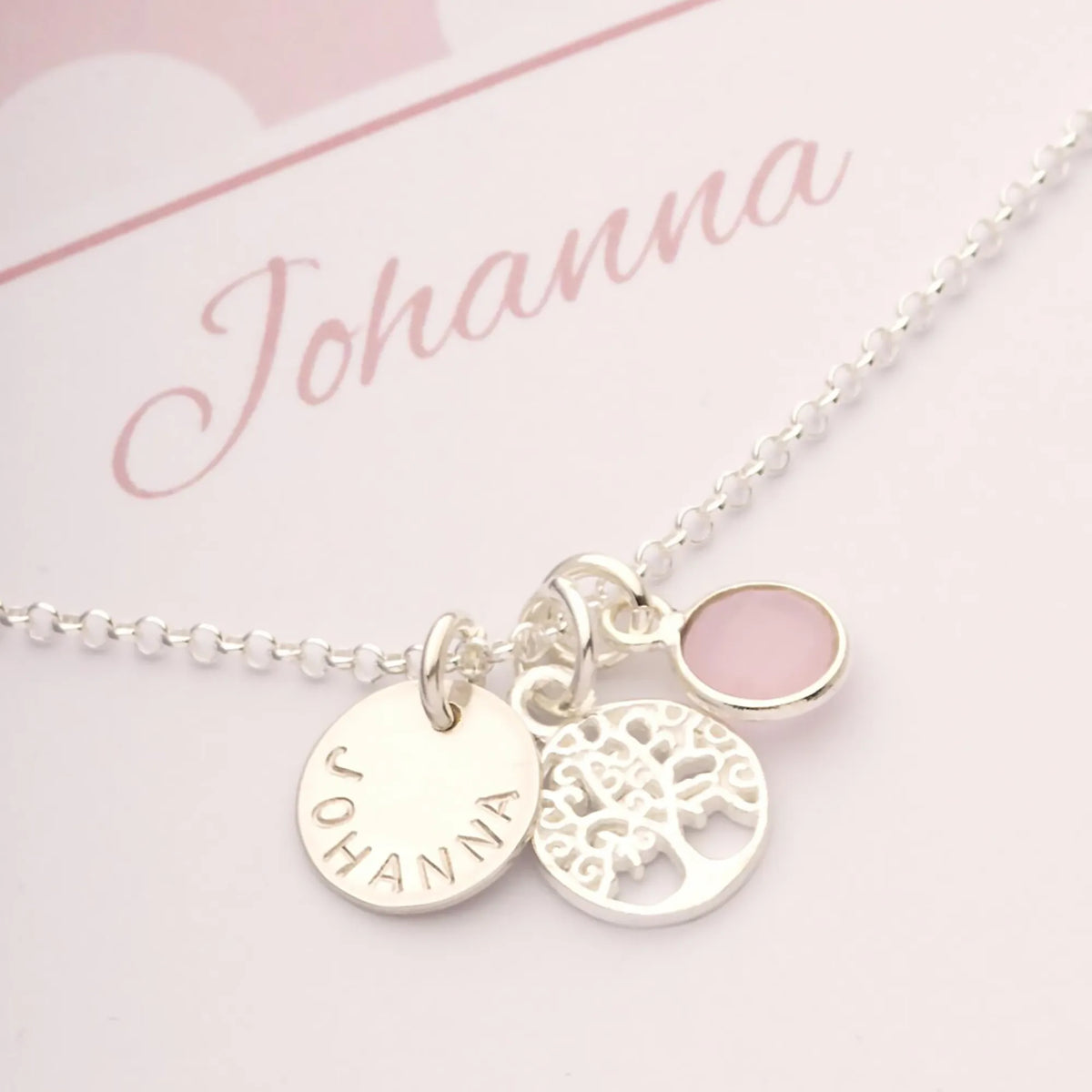 Eine personalisierte Silberkette für  Mädchen aus 925 Sterling Silber mit Lebensbaum, handgestempeltem Namenstaler und Rosenquarz.