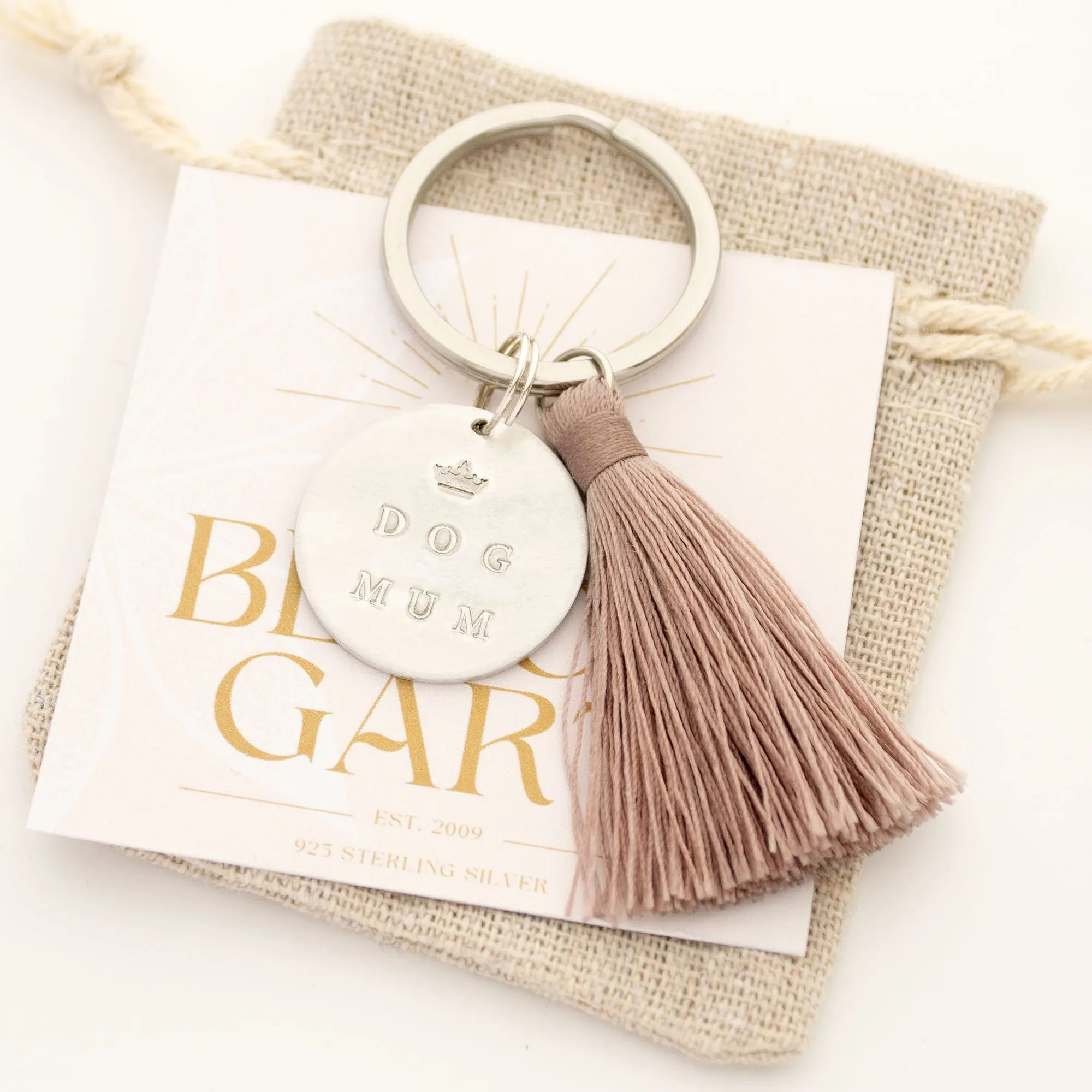 Individueller Schlüsselanhänger von Hand gestempelt mit 'DOG MUM' oder 'DOG DAD', taupefarbene Quaste, verpackt in Boho Leinen-Säckchen von Bloomgart.