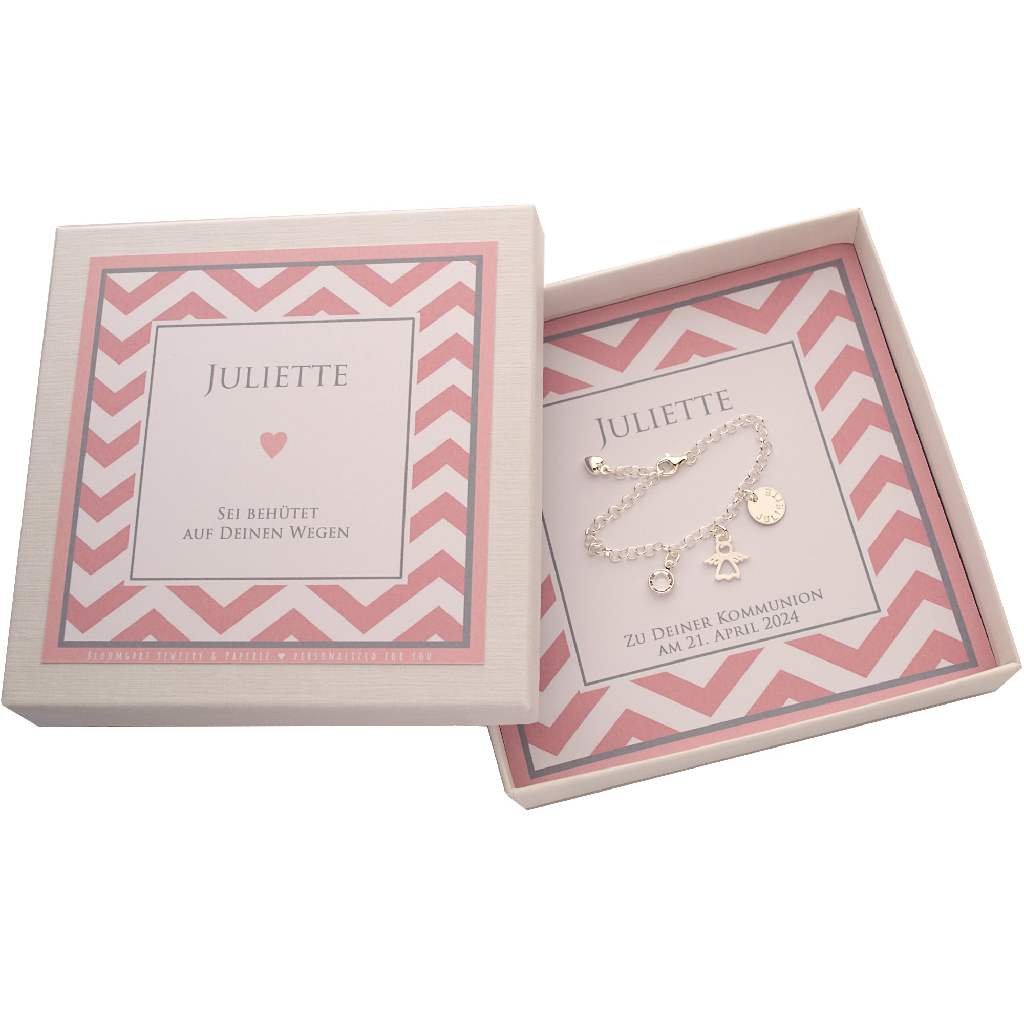 Komplettansicht einer personalisierten Geschenkboxbox für "Juliette" mit Spruch "Sei behütet auf deinen Wegen" und rosa Zickzack-Muster. Innenliegend befindet sich das Silberarmband mit Schutzengel, Namensanhänger und Geburtsstein.
