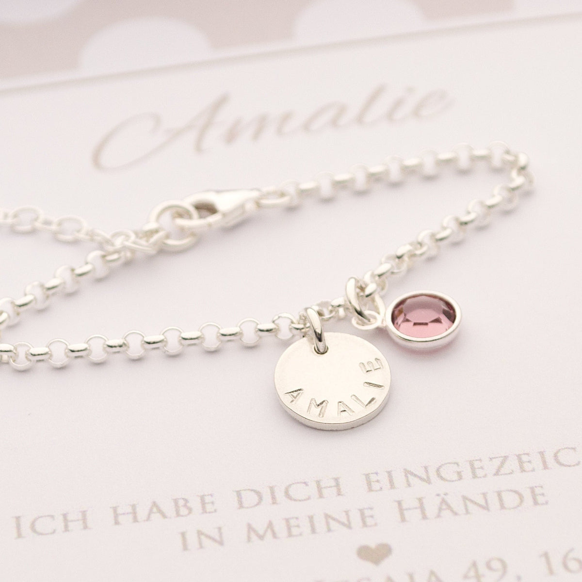 Handgestempelte Gravur: Detailfoto des Taufarmbands aus 925 Silber, das den von Hand gravierten Namen "Amalie" und einen funkelnden Geburtsstein zeigt.