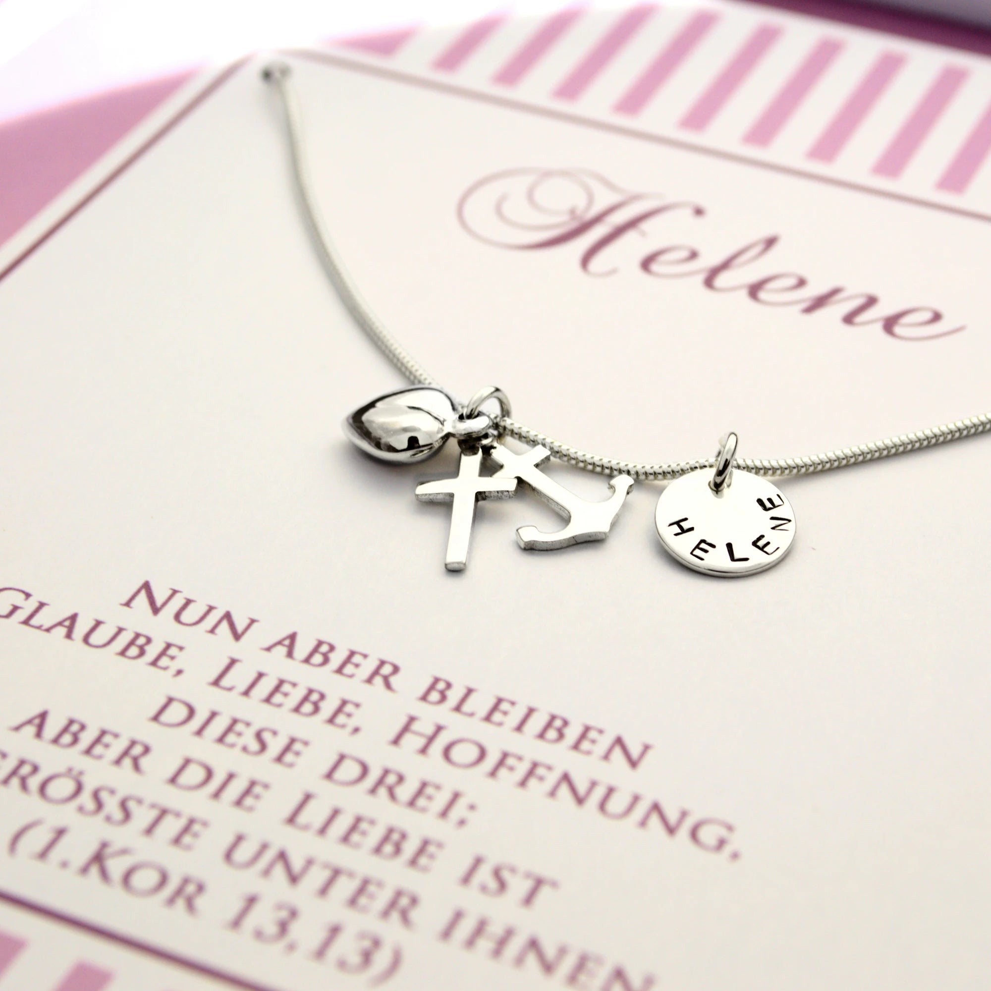 Detailansicht einer personalisierten Taufkette aus 925 Silber mit Wunschgravur Name, hier HELENE und Anhängern für Glaube (Kreuz), Hoffnung (Anker) und Taufe (Herz) in einer personalisierten Geschenkbox von Bloomgart