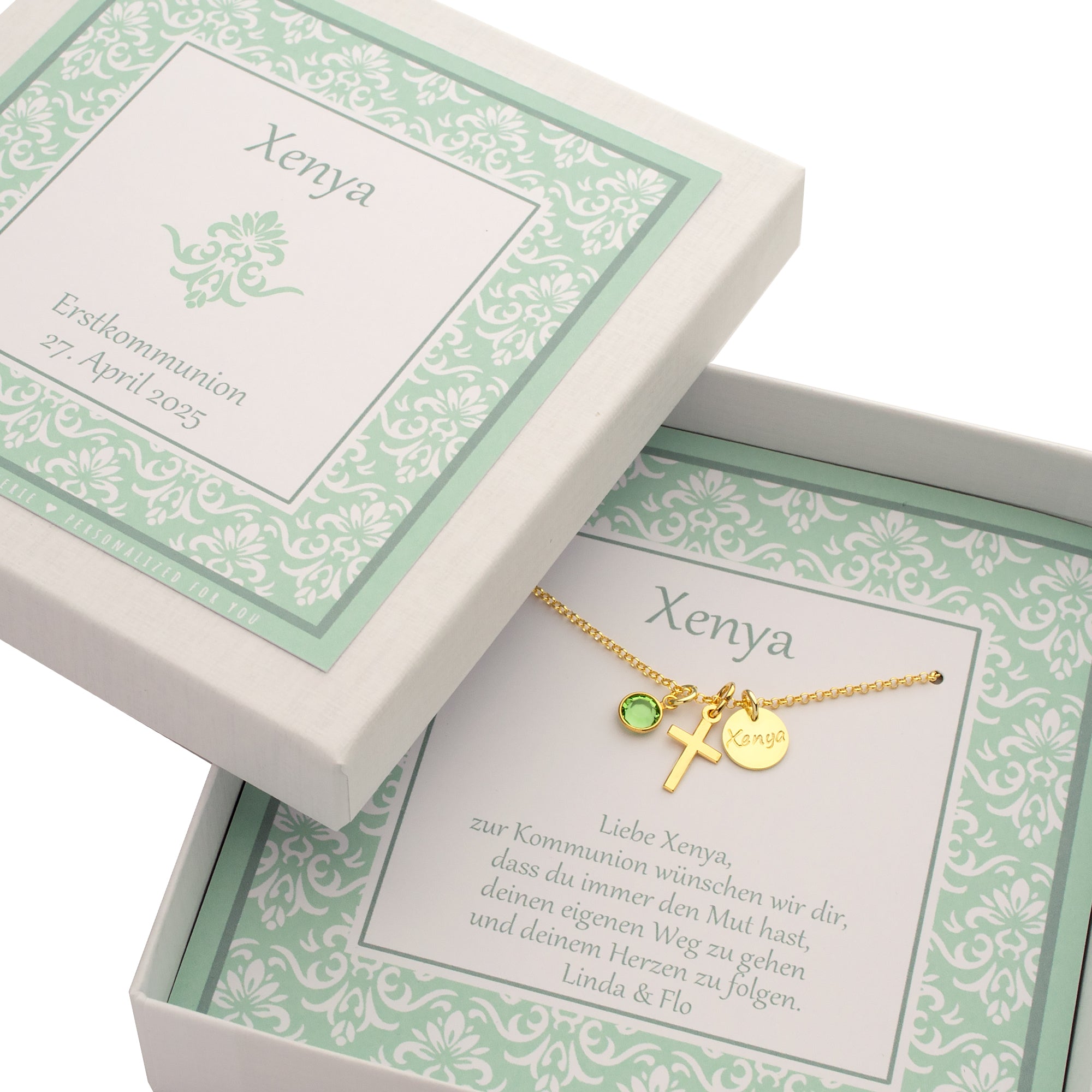 Gesamtansicht einer Geschenkbox, personalisiert für Xenya zur Erstkommunion. Innenliegend ist eine Goldkette mit Kreuz, Namenstaler und Geburtsstein montiert und mit Namen und Wünschen versehen.