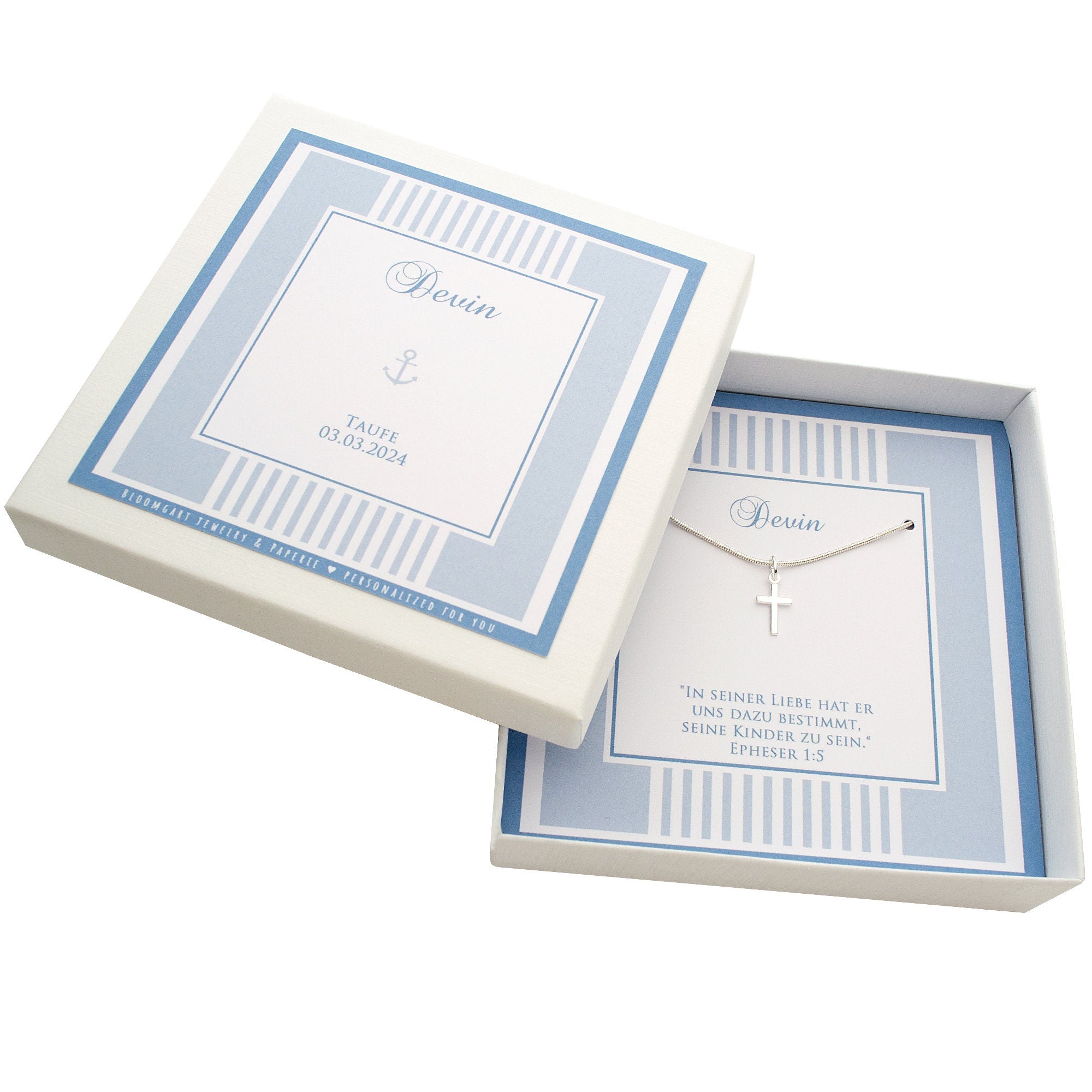 Personalisierte Taufkette aus 925 Silber mit Kreuz-Anhänger für 'Devin'. Präsentiert in einer hellblau-weißen Geschenkbox mit Taufdatum und dem Taufspruch aus Epheser 1:5. Ein klassisches Taufgeschenk von Bloomgart.