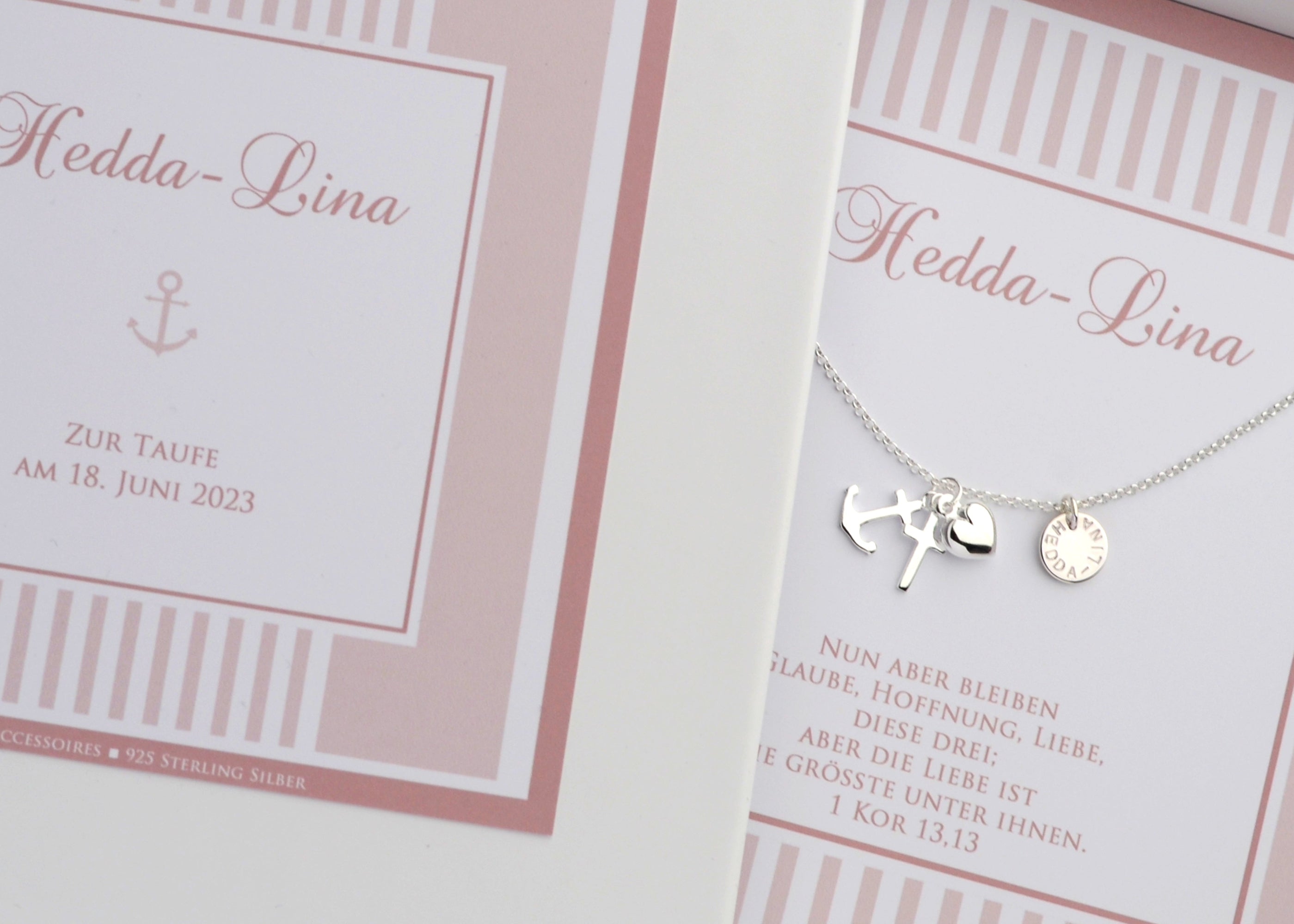 Personalisierte Halskette aus 925 Sterling Silber mit Anhängern für Glaube (Kreuz), Liebe (Herz) und Hoffnung (Anker) sowie einem Gravurplättchen mit dem Namen "Hedda-Lina". Die Kette liegt in einer rosa personalisierten Geschenkbox.