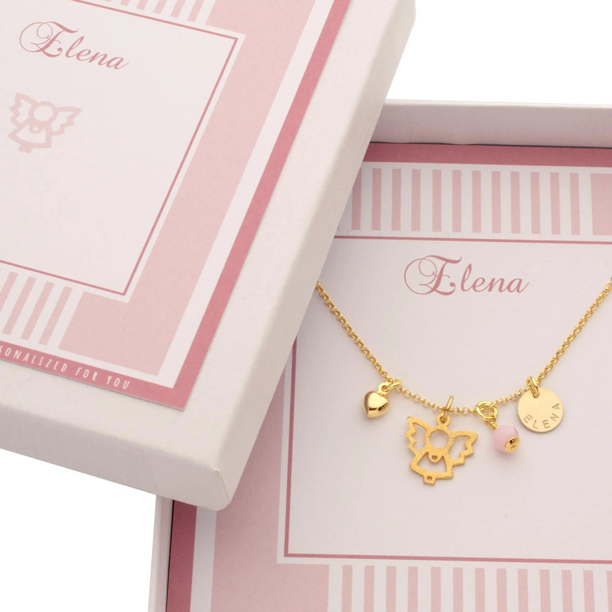Eine vergoldete Halskette mit Herz, Engel, rosa Stein und Namenstaler in einer weiß-rosa Geschenkbox mit Namen personalisiert.