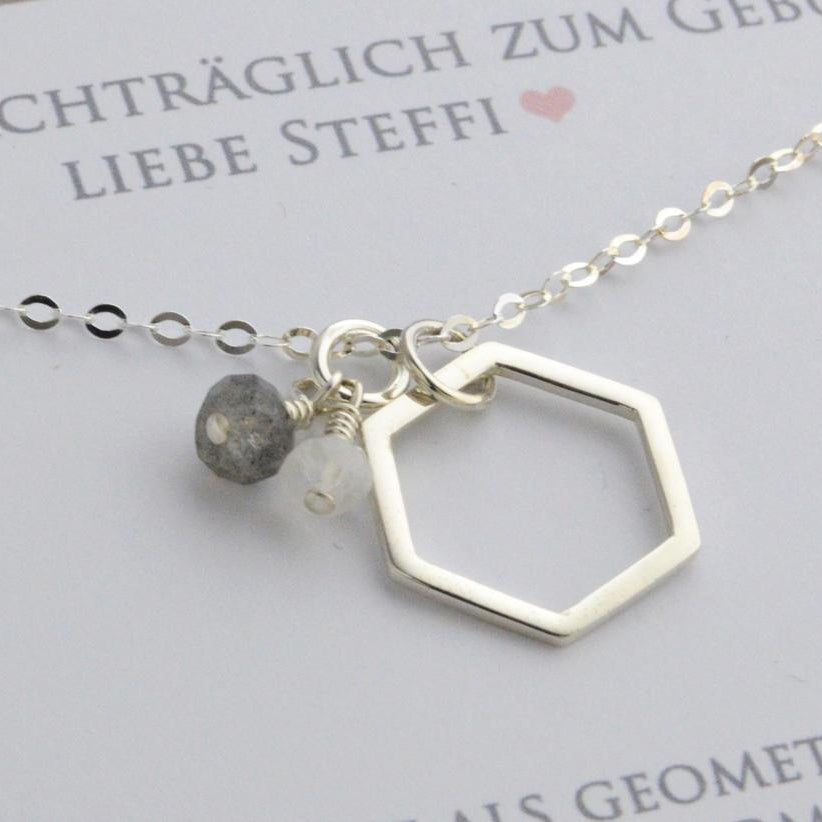 Detailansicht einer 925 Silber Ankerkette mit Hexagon-Anhänger und zwei kleinen Edelsteinen, einem Labradorit und einem Mondstein in einer zum Geburtstag personalisierten Geschenkbox.